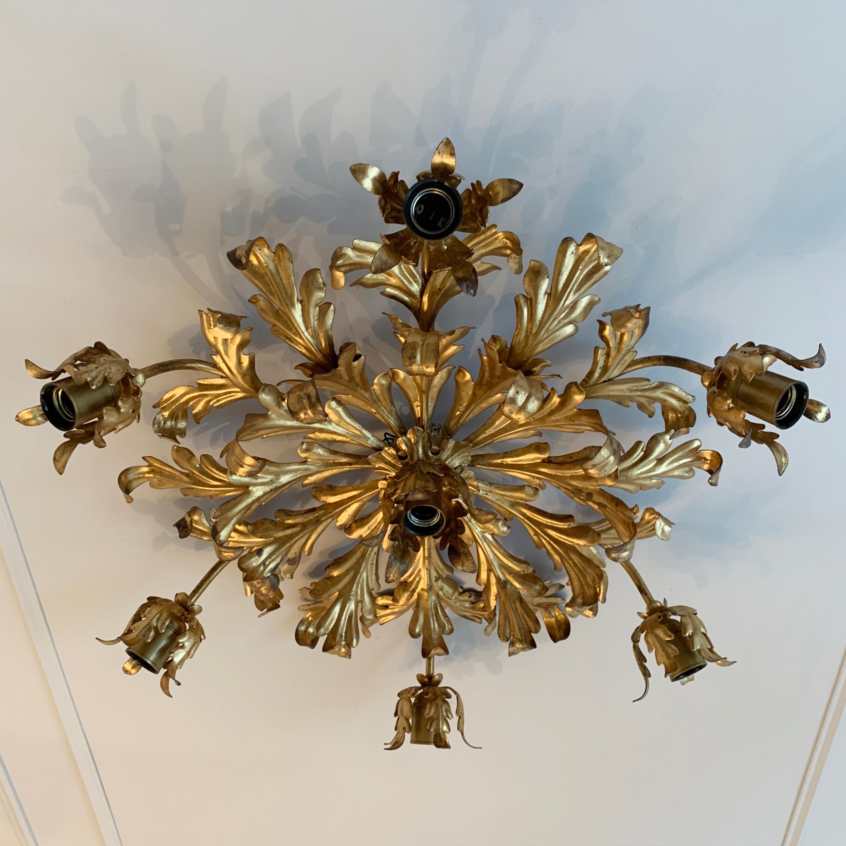 Large French gilt acanthus leaf flush light, circa 1960s
This decorative gilt metal light is designed with acanthus leaves and stems leading to ornate buds which cradle the lamp holders
There is a single lamp holder in a centre bud too
The light