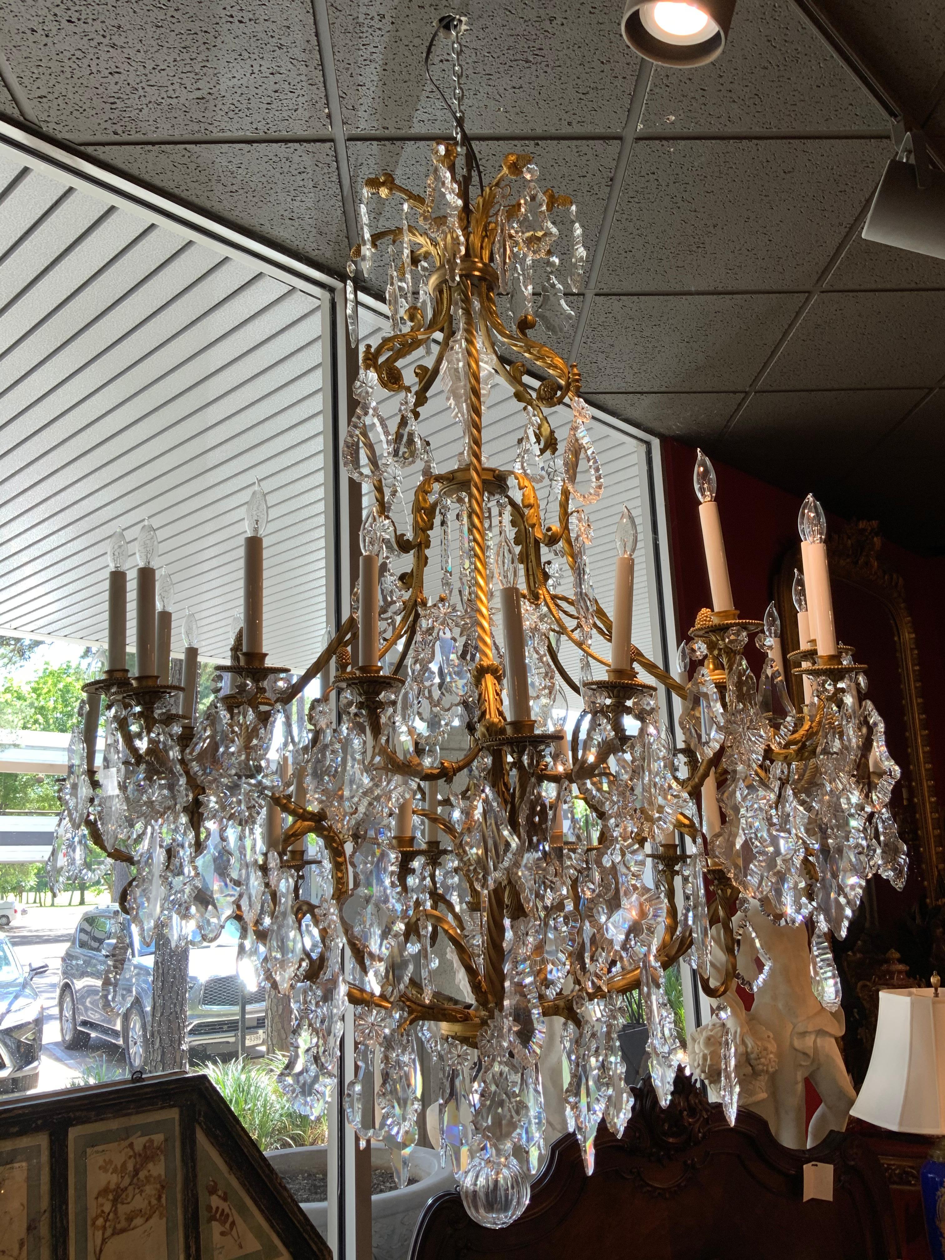 Elegant crystal chandelier having 24 lights, complete without missing or chipped crystal.
Six bronze roped arms emanate from the top crown. Exquisite scrolling arms each support 
The candles. Beautifully cast acorn finials are mounted throughout.