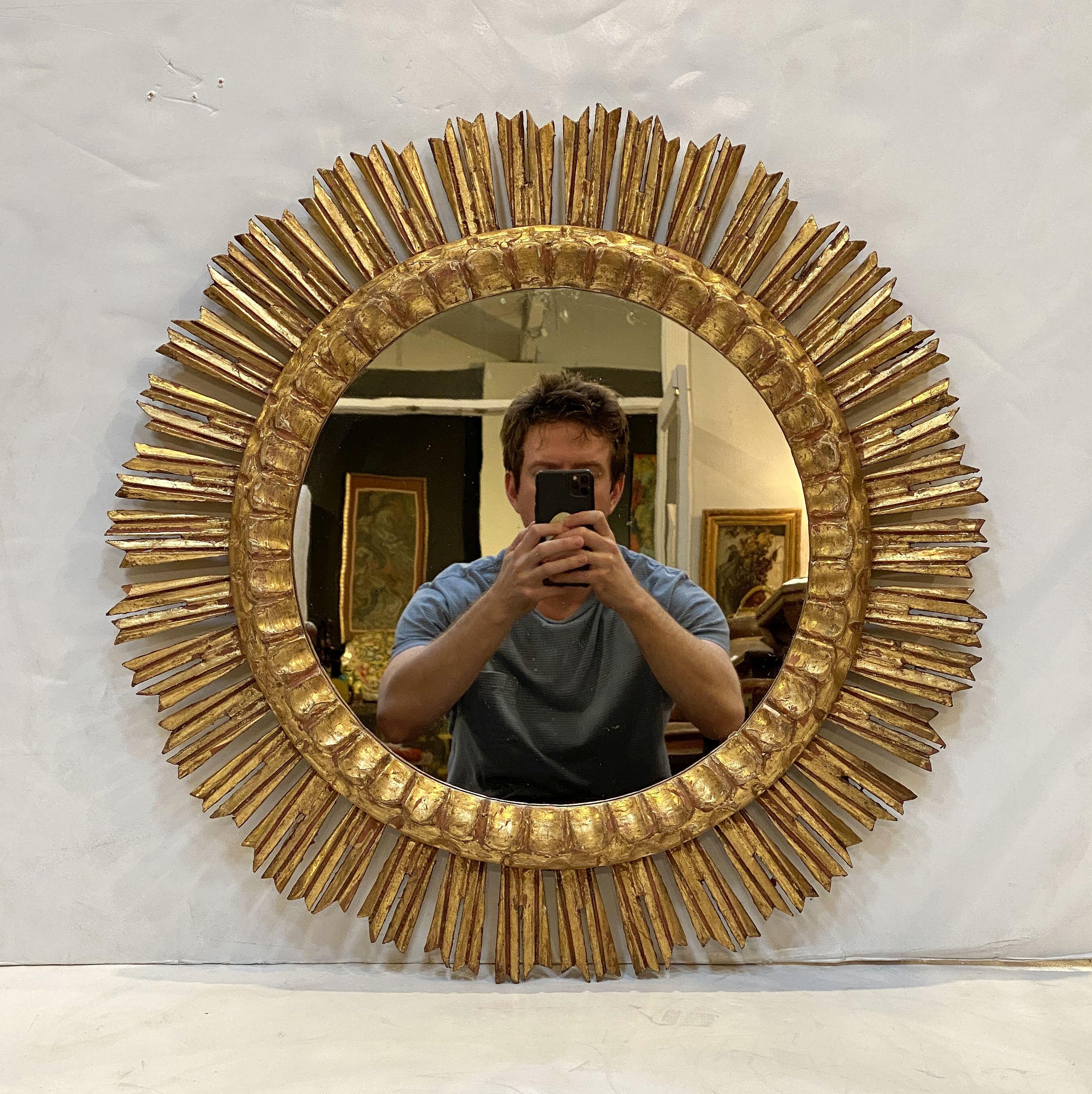 A lovely large French gilt sunburst (or starburst) mirror, 24 1/4 inches diameter with round mirrored glass center in a moulded frame.