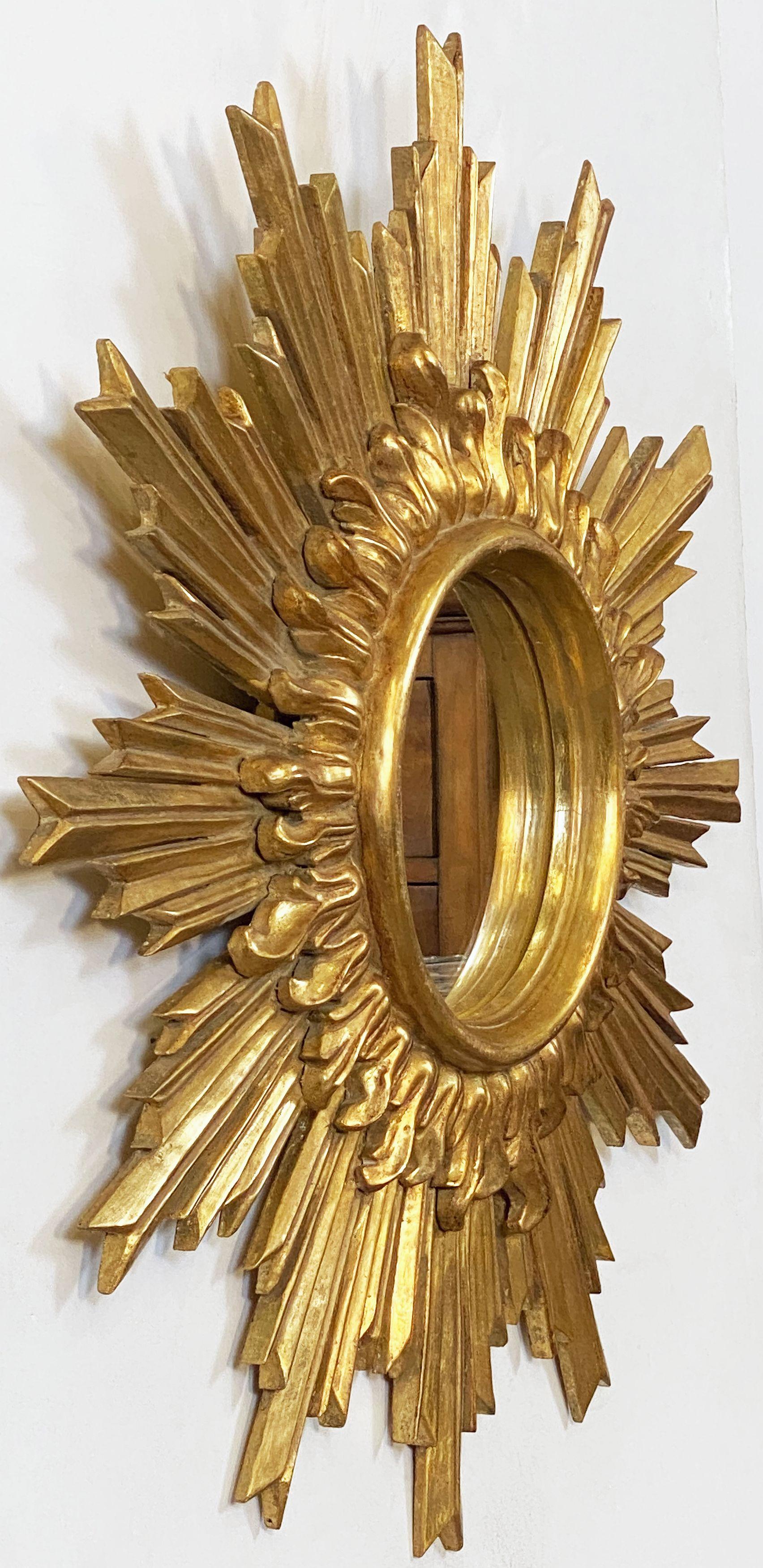A large French gilt sunburst (or starburst) mirror featuring a lovely double layer of golden rays - with round mirrored glass center in moulded frame.

Outside Diameter of 26 1/2 inches

Diameter of interior mirror is 7 5/8 inches