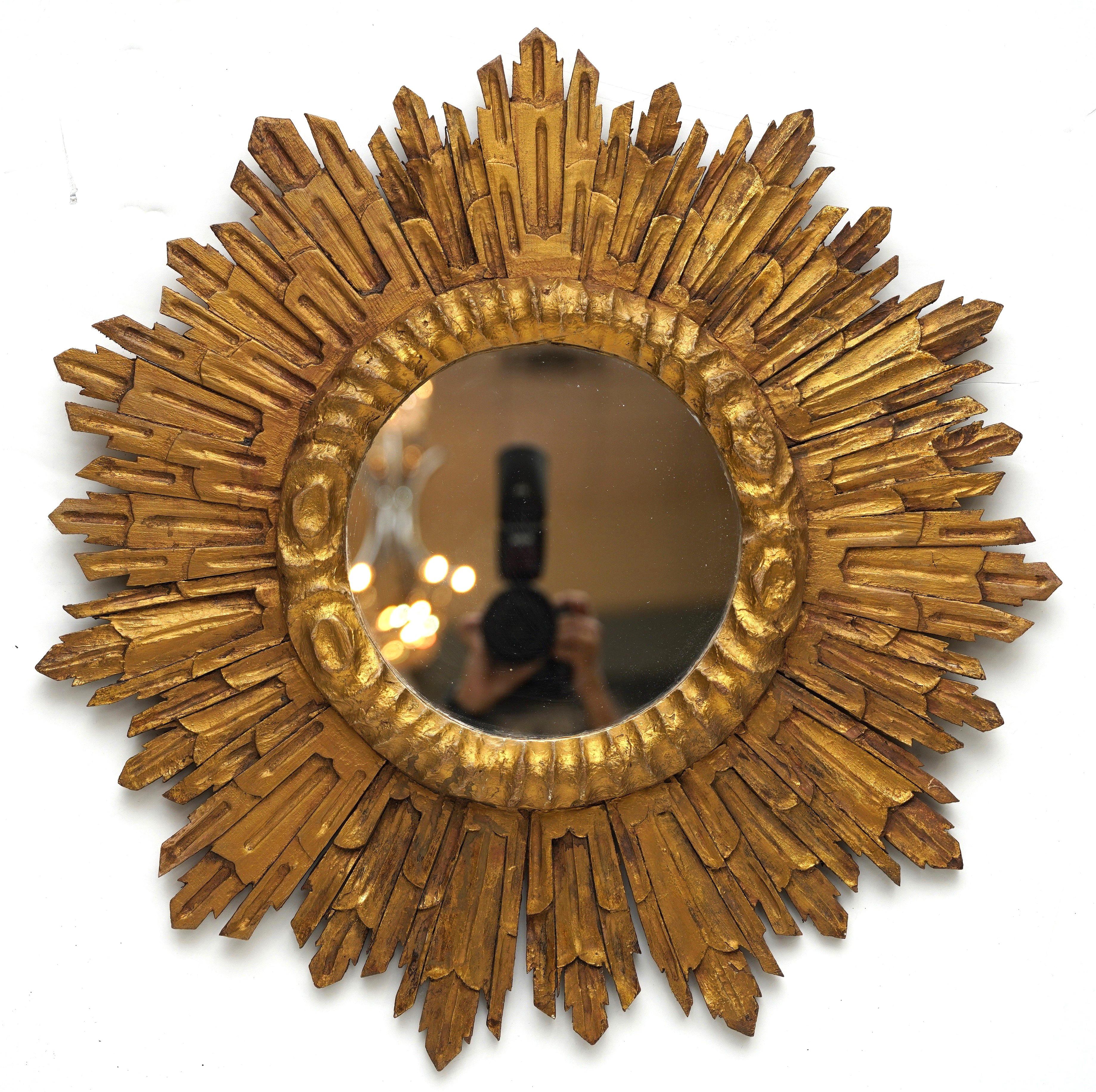 A large French gilt sunburst (or starburst) mirror with round mirrored glass center in a lovely moulded giltwood frame.

Diameter of 27 1/2 inches