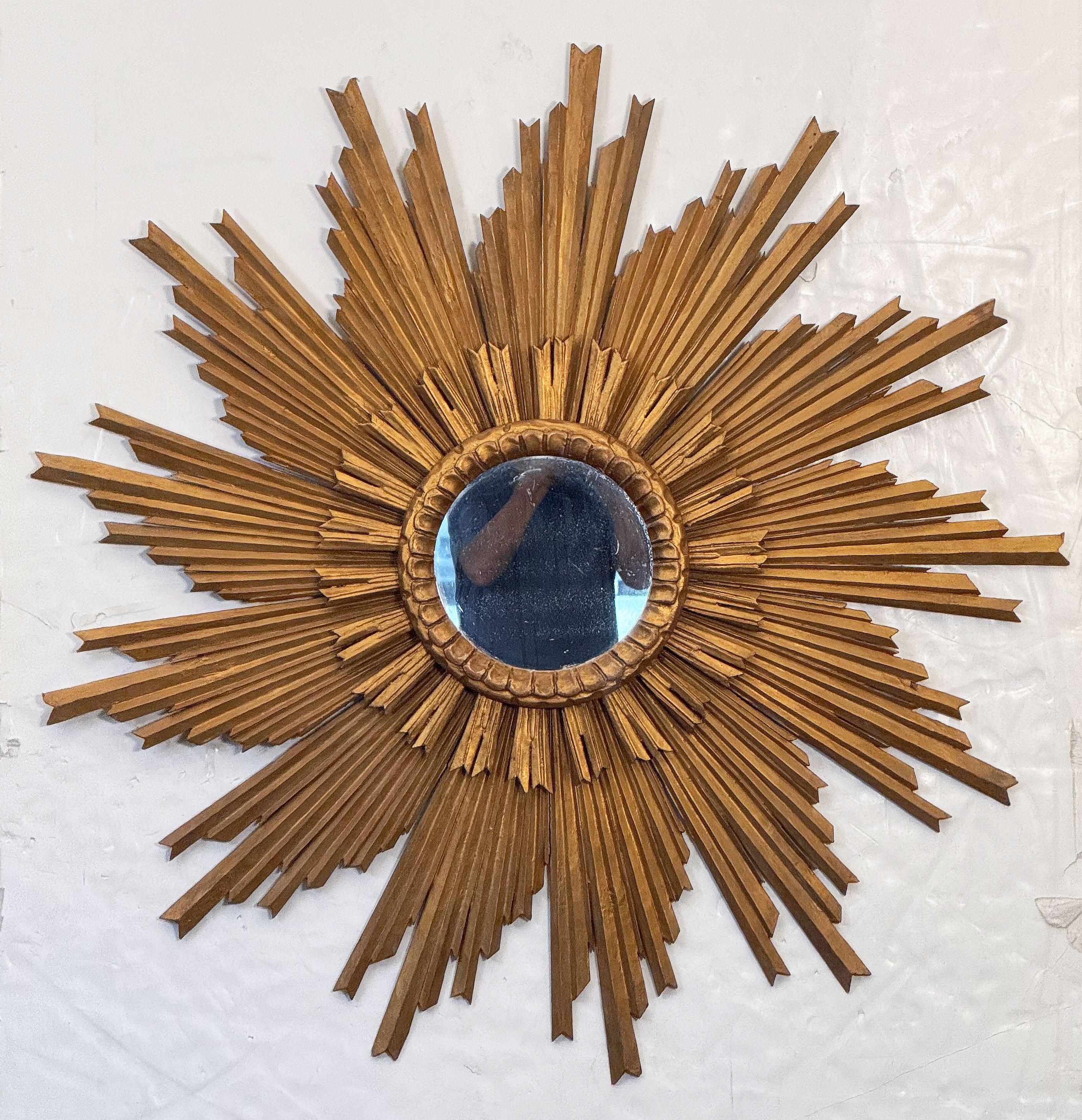 A beautiful large French gilt sunburst (or starburst) mirror in a lovely moulded giltwood frame, featuring a multi-level arrangement of rays emanating from a round mirrored glass center.

Diameter of 45 1/2 inches