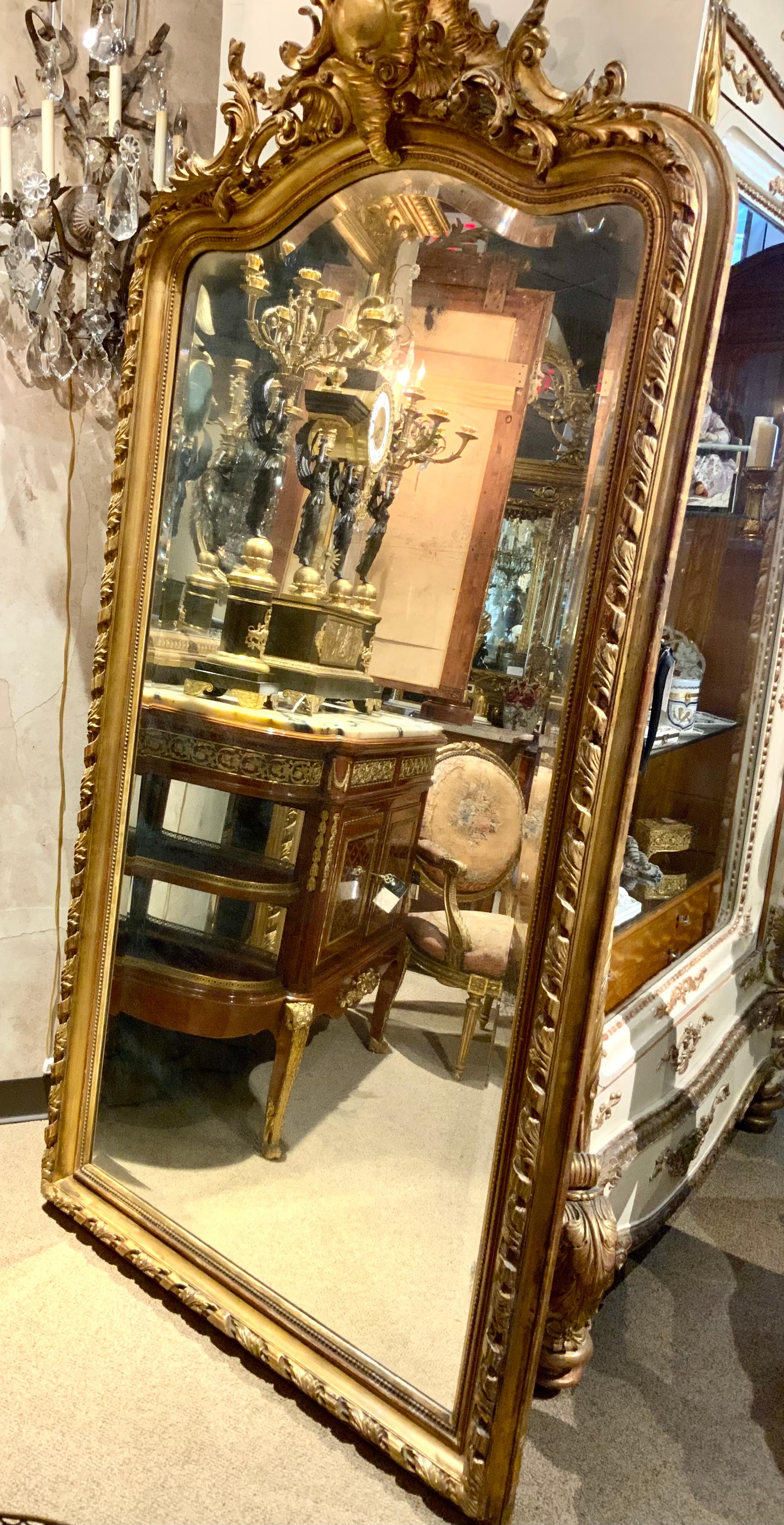 Large and majestic giltwood mirror with a wide beveled plate make this
Mirror special. It has beautiful and original gilding with a deep carved
Cartouche centered at the top. Carved swirl designs across the top
Edge add to the overall attraction