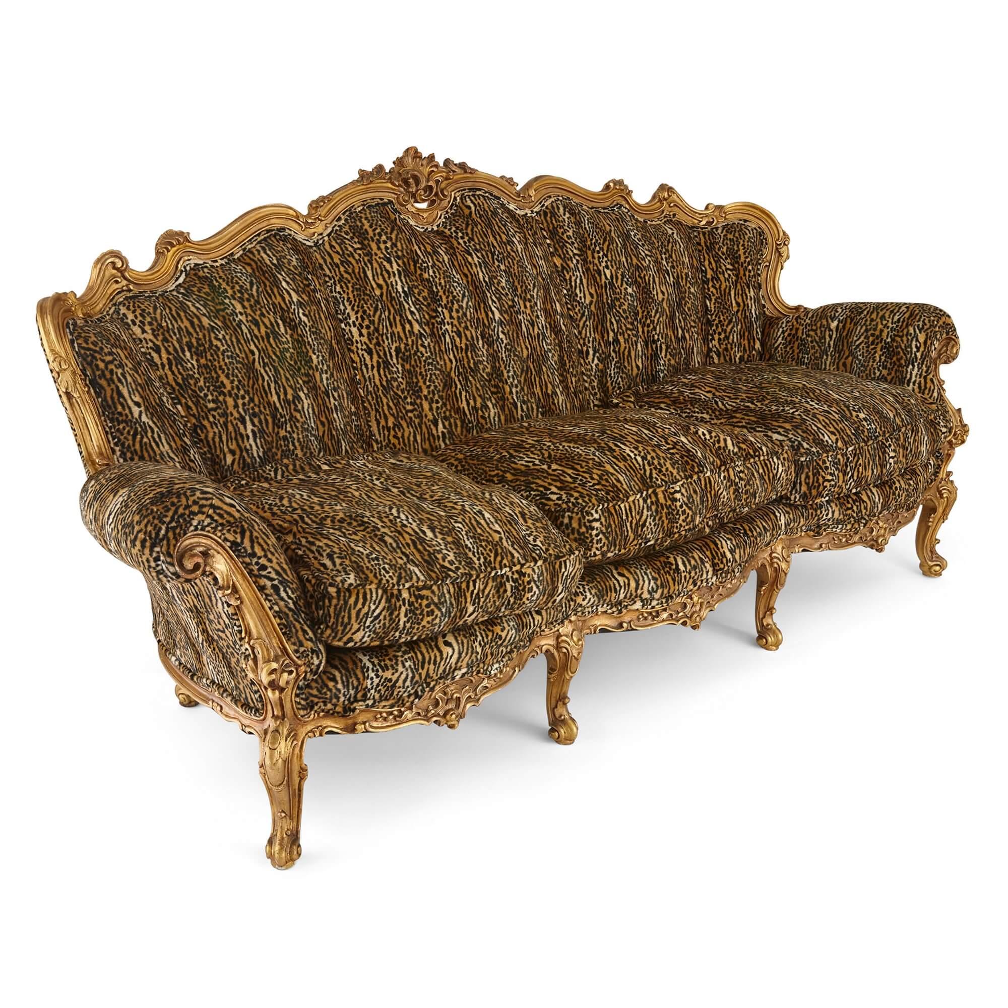 Grand canapé ancien français orné de bois doré
Français, Début du 20e siècle
Hauteur 100cm, largeur 214cm, profondeur 75cm

Tapissé de somptueux motifs décoratifs en peau de léopard, ce canapé remarquablement grand, luxueux et orné est fabriqué