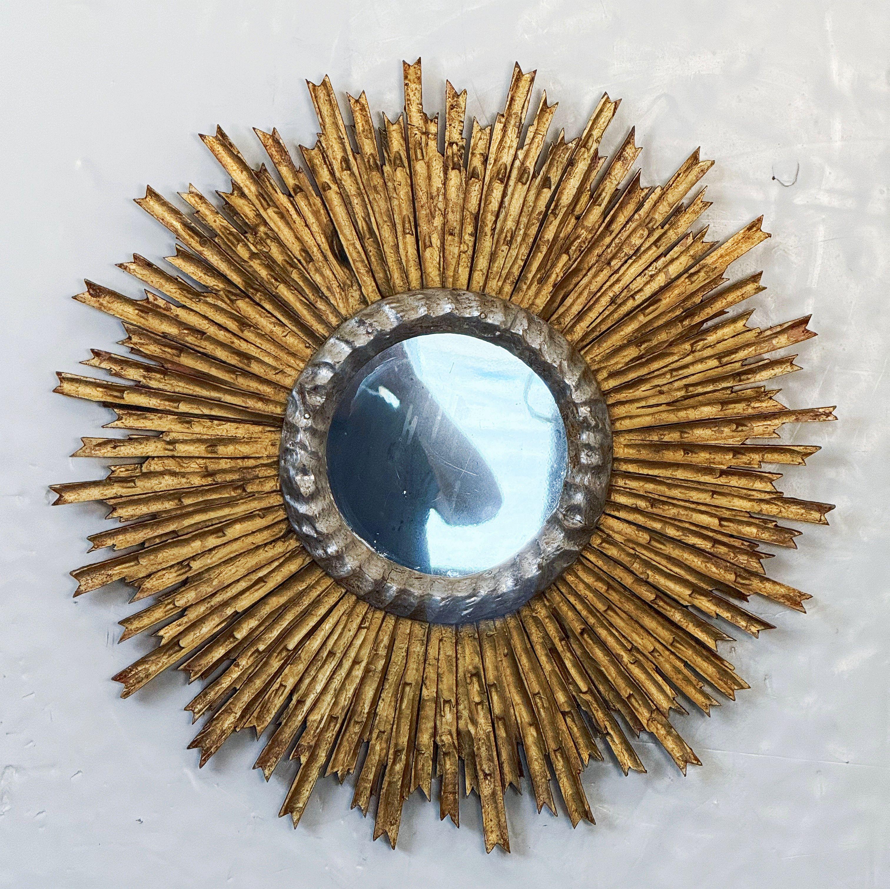 A fine large French gilt sunburst (or starburst) mirror with beautifully gilded wooden rays arranged around a silver gilt circular ring surrounding the mirror plate center.

Diameter is 27 1/4 inches