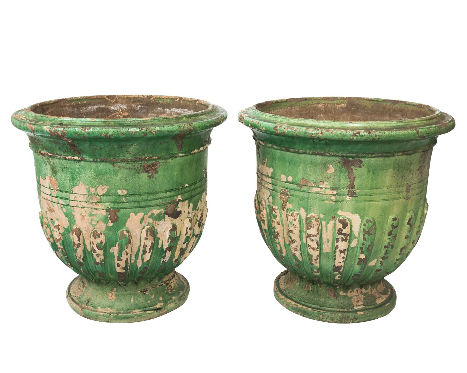 Large French green glazed urn in a distressed finish, circa 20th century. Please note of wear consistent with age causing paint loss.