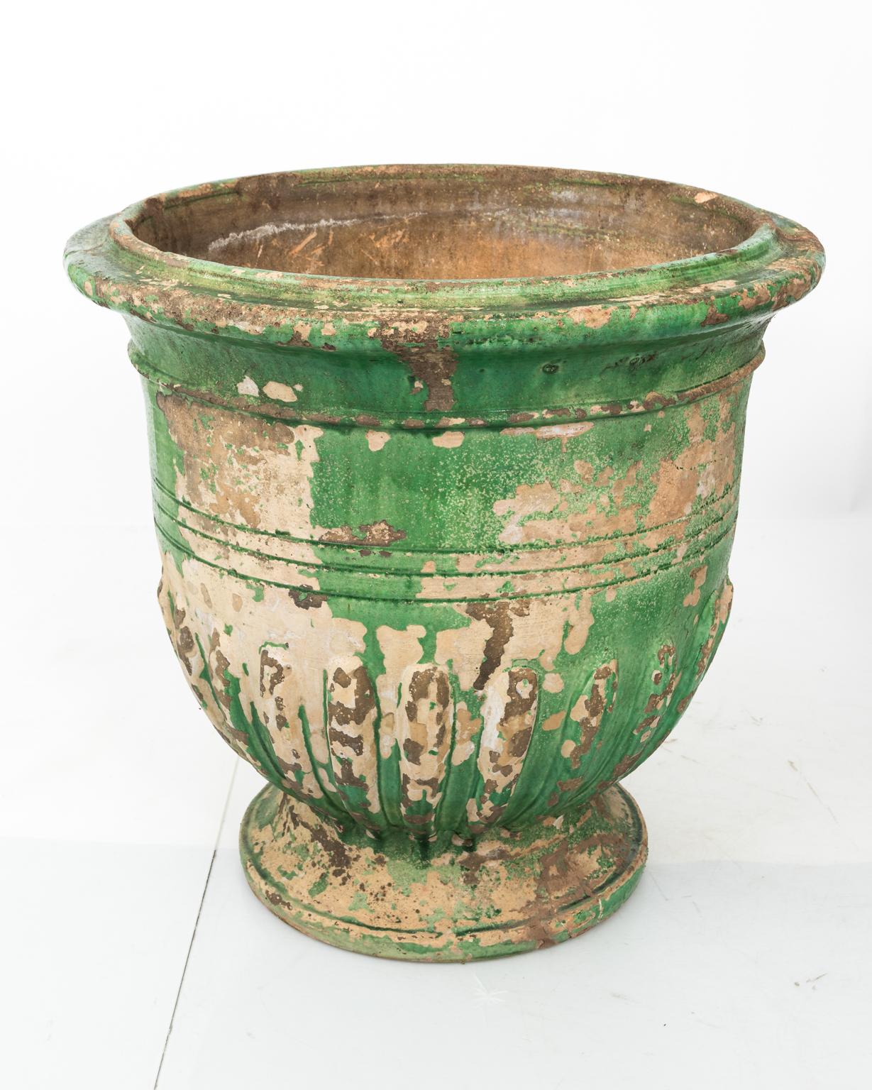 Large French green glazed ceramic urn in a distressed finish, circa 20th century. Please note of wear consistent with age causing paint loss.