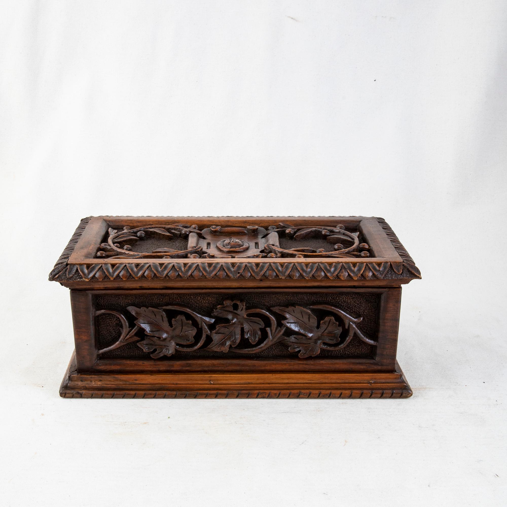Measuring 12.25 inches wide by 6.5 inches deep, this large French hand carved box from the turn of the twentieth century features a central cartouche on the top monogrammed with the letter A flanked by olive branches. The top is trimmed with a