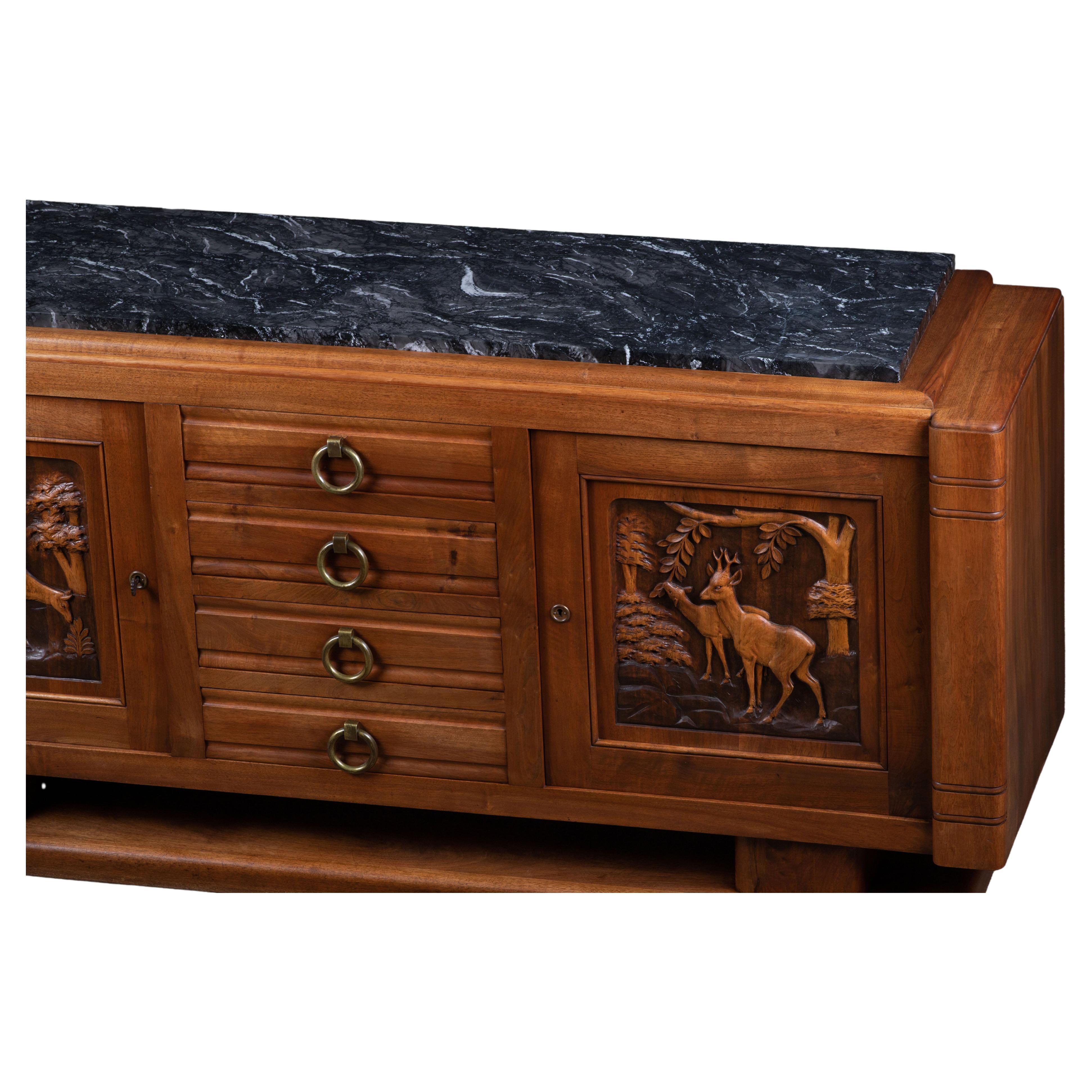 A large handcarved sideboard / credenza France, c1940s.
Consists of 4 central drawer and two storage compartments. 
Inlaid wood center shelves, brass detailing and handcarved design doors make this piece really stand out.
The sideboard is in