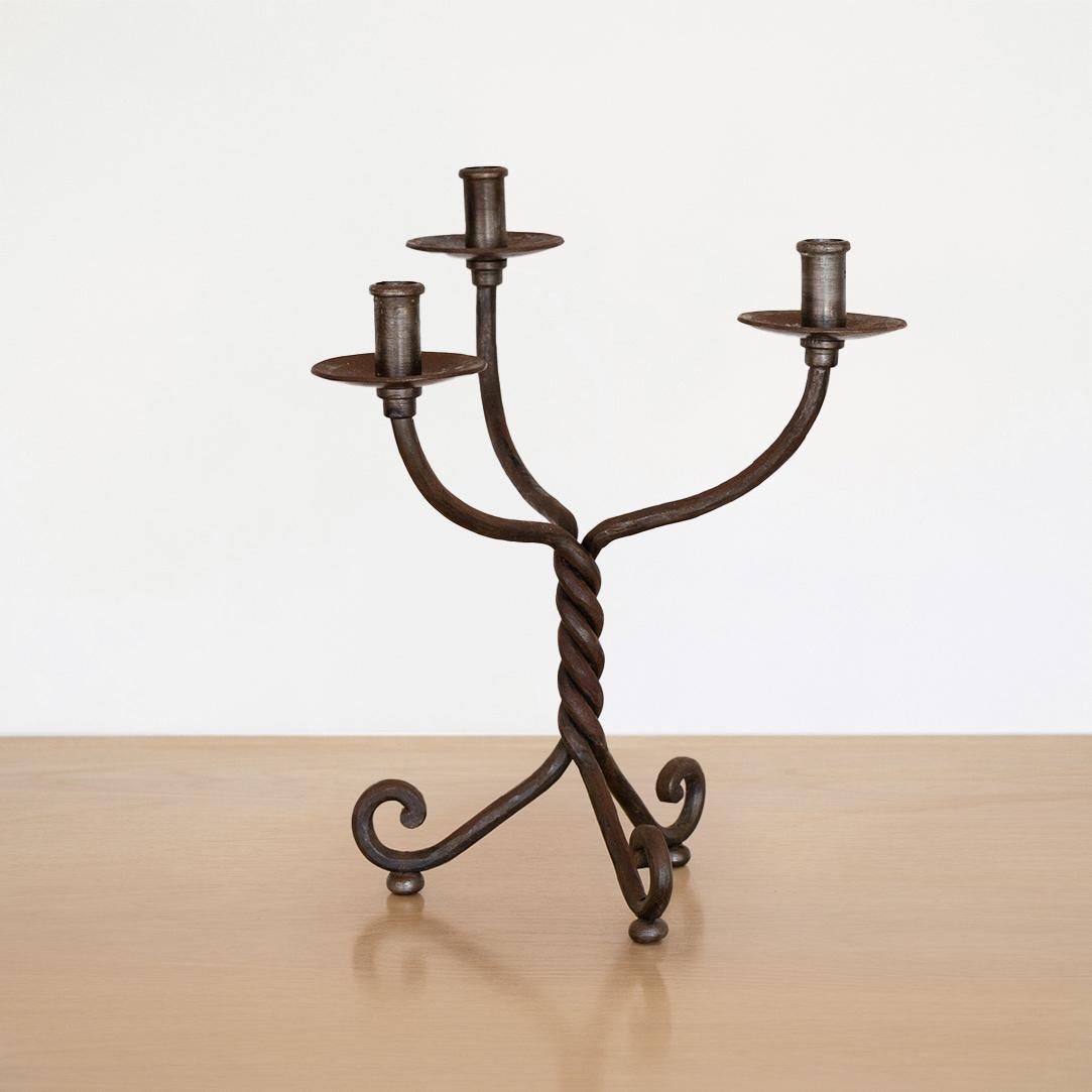 Large iron 3-arm candelabra from France. Twisted iron stem and three leg base with loop detail. Beautiful age and patina to finish.