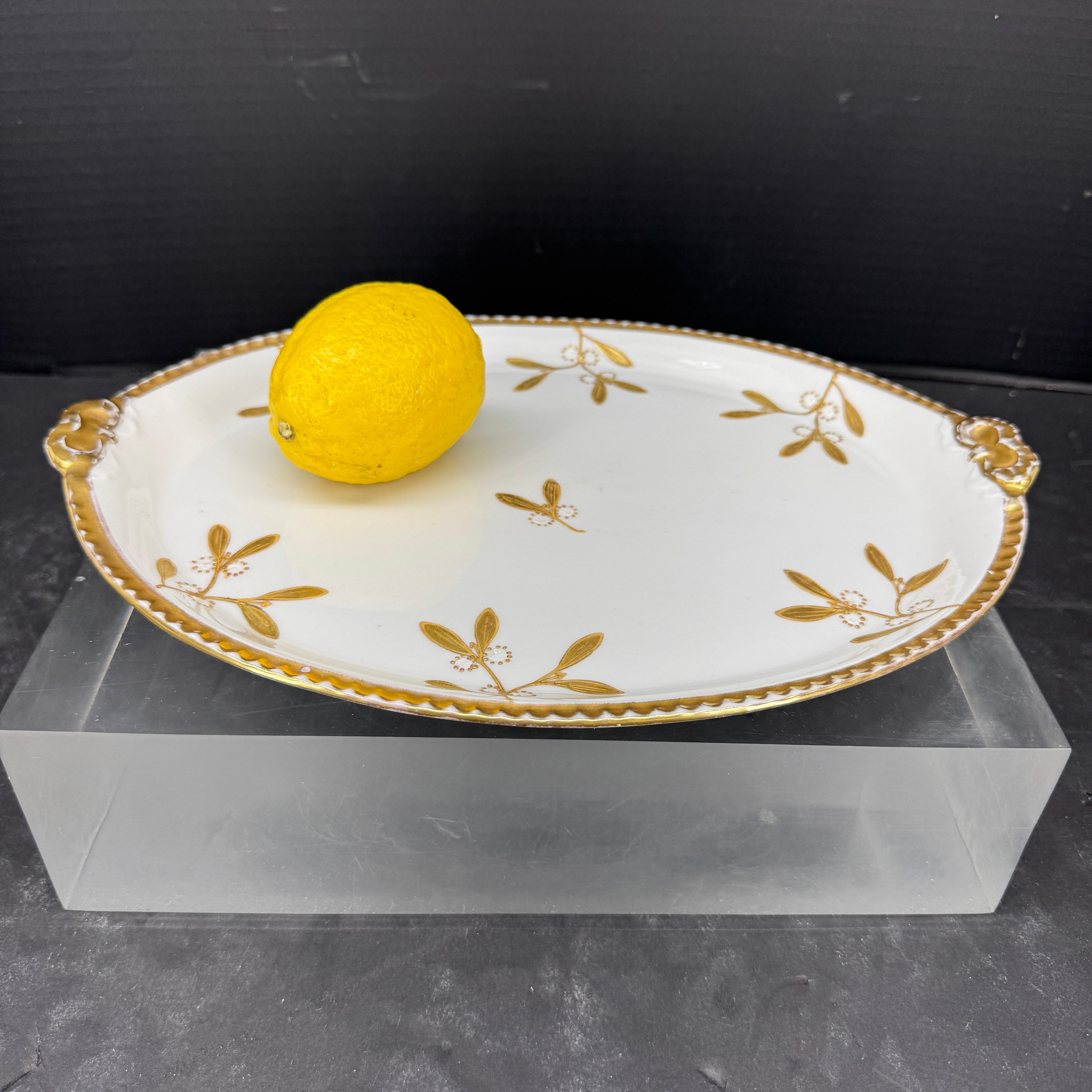 Como las que se encuentran en Francia, esta pieza Limoge de mayor tamaño presenta un diseño floral pintado a mano con detalles dorados y biselados. Esta pieza sería sin duda una fantástica adición a una colección existente de estos deseables platos,