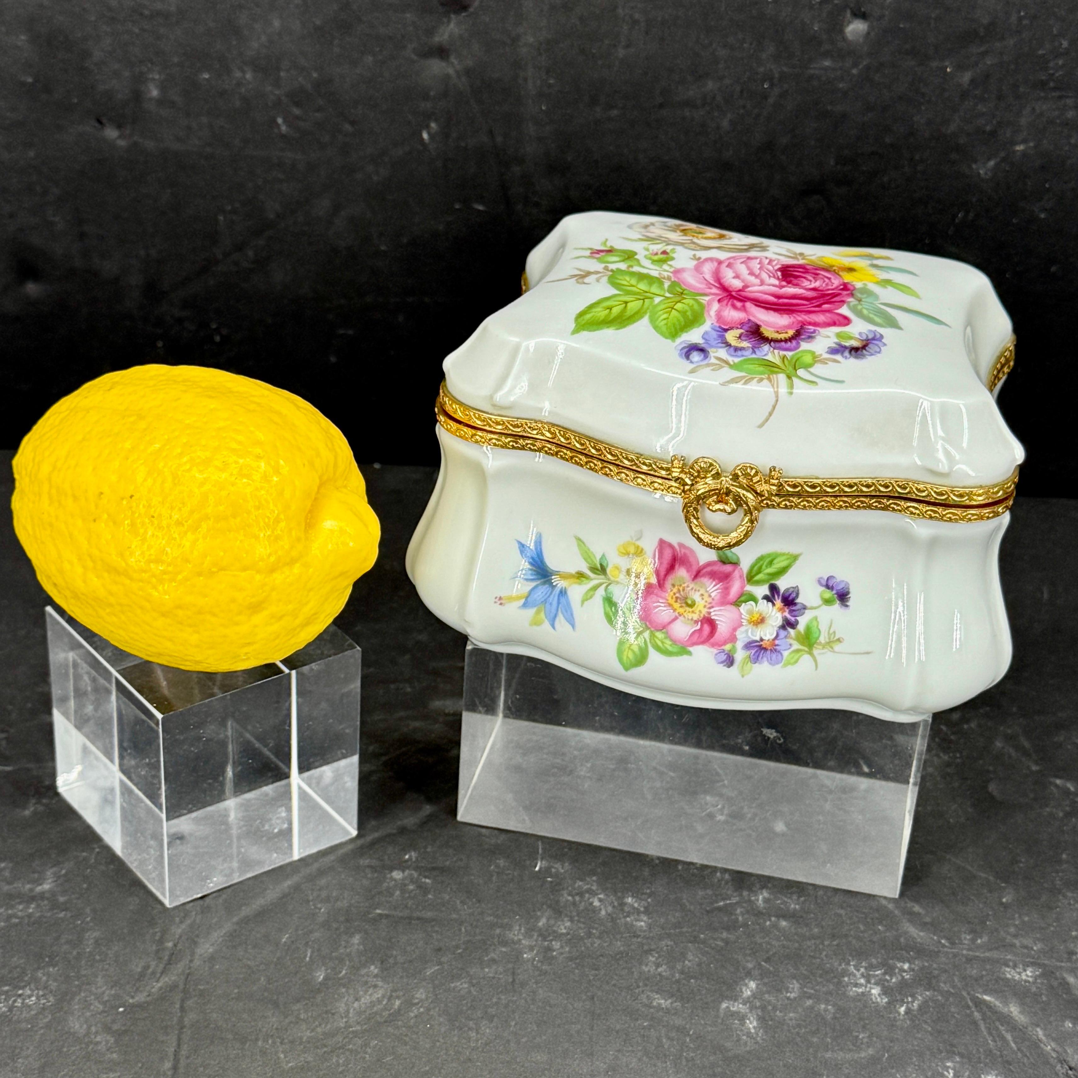 As found in Paris, an impressive Limoges hand painted box. The colors of pink, blue, purple, yellow and green painted on this box are fantastic and certainly colorful. The gold clasp certainly makes this piece very elegant. The underside of the box