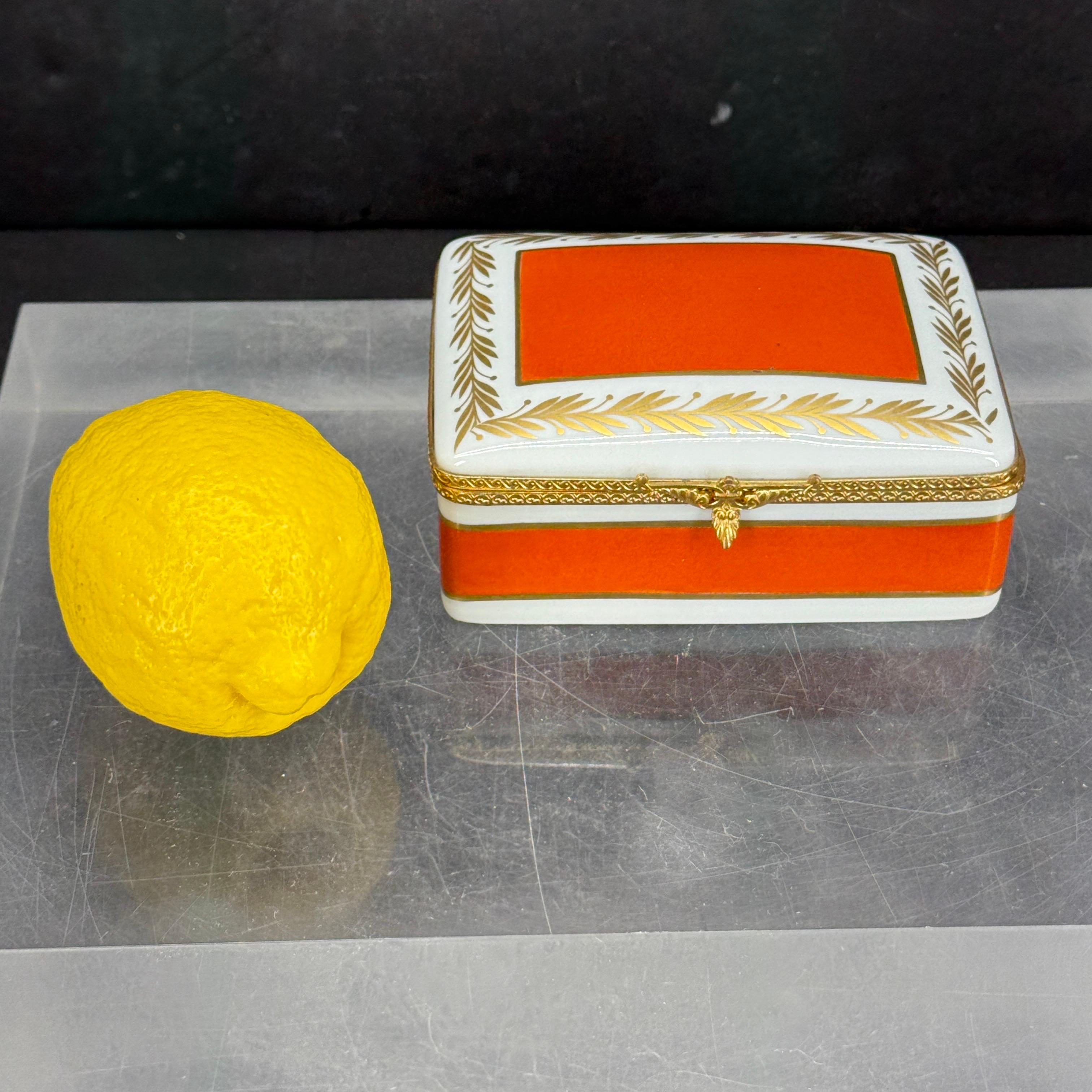 Comme à Paris, une impressionnante boîte peinte à la main à Limoges. Les couleurs de cette boîte sont fantastiques, l'orange est peint ce que nous décririons comme l'orange Hermès. La dorure rend cette pièce très élégante. Le dessous de la boîte est