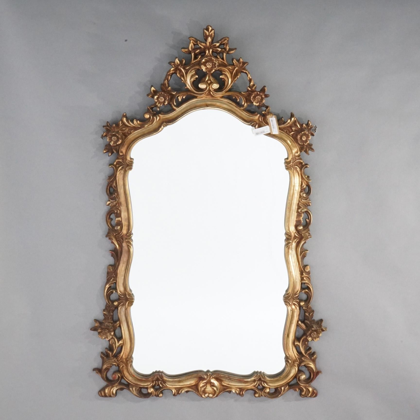 A large French Louis XIV style wall mirror offers gilt syroco construction with elaborate foliate frame, 20th century

Measures- 56.5''H x 35.75''W x 2.25''D.
