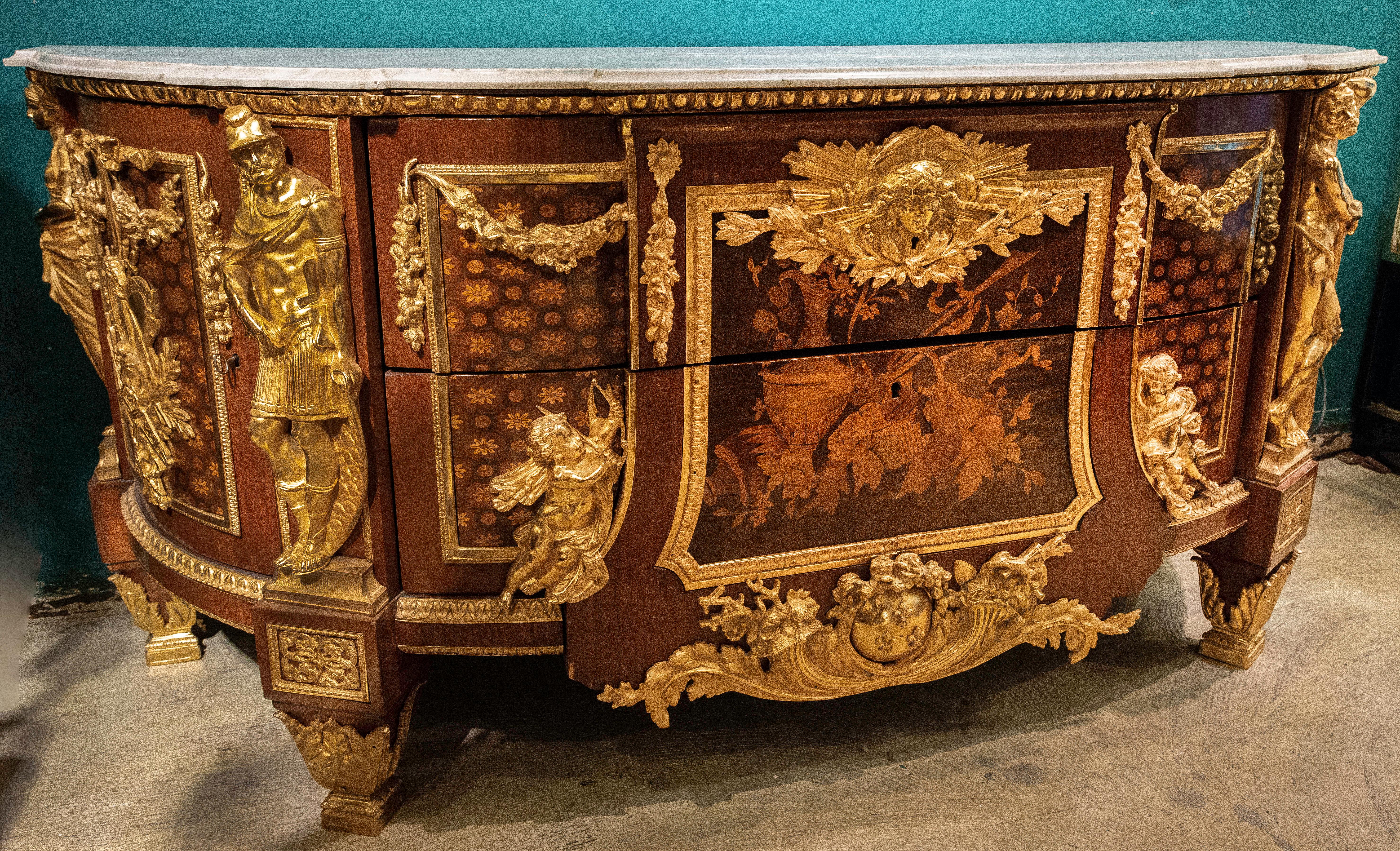 A fine and large French early 20th century Louis XVI style mahogany, kingwood and fruitwood marquetry armorial commode with sycamore marquetry and gilt bronze mounts, after a model of The Commode Commandée Pour La Chambre de Louis XVI à Versailles