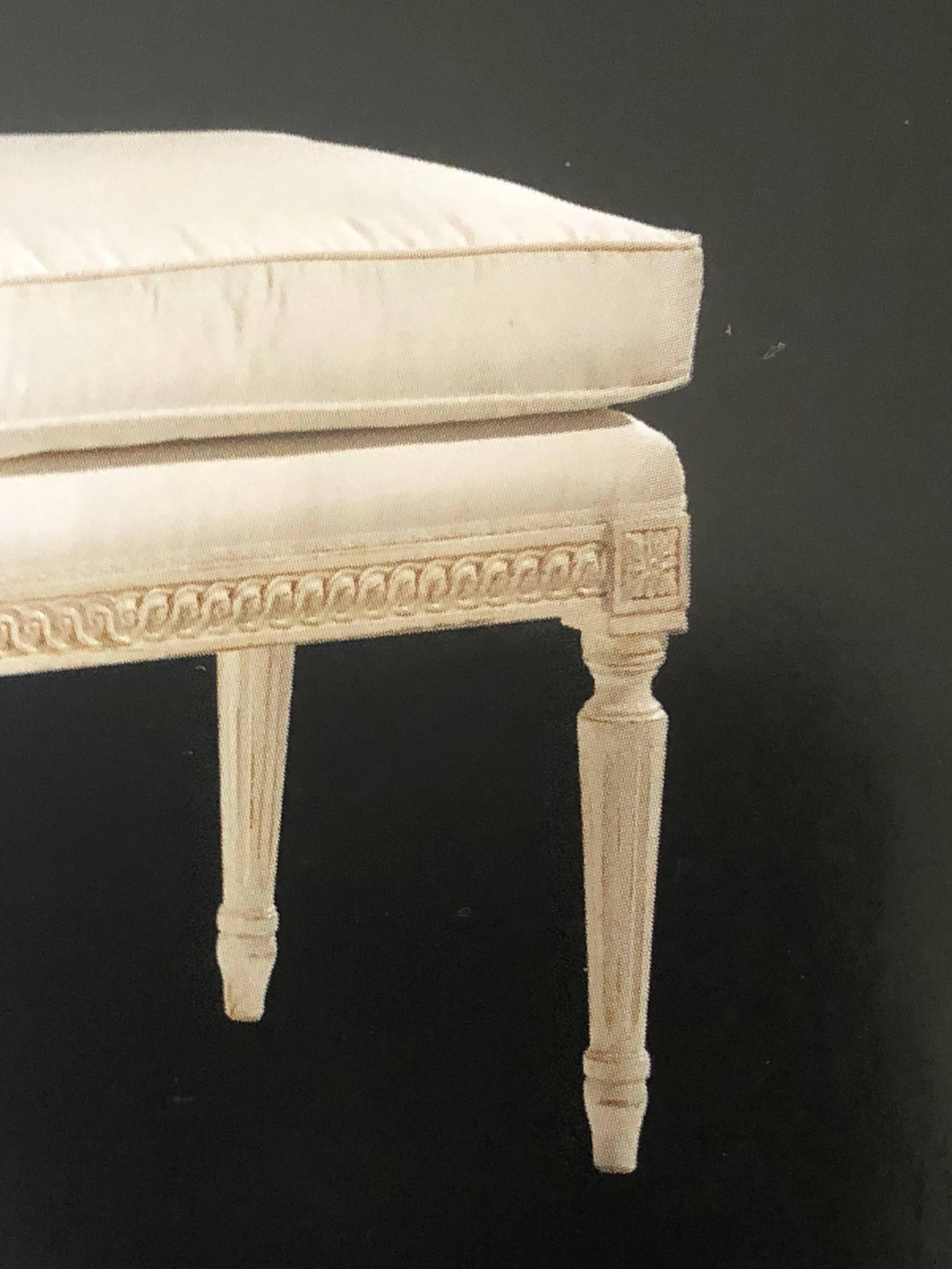 Large French Louis XVI style bench in the style of Maison Jansen.

Carved from hardwood with tapered legs and with antiqued white finish, off-white upholstery and loose fitting cushion. 

Priced and sold individually.