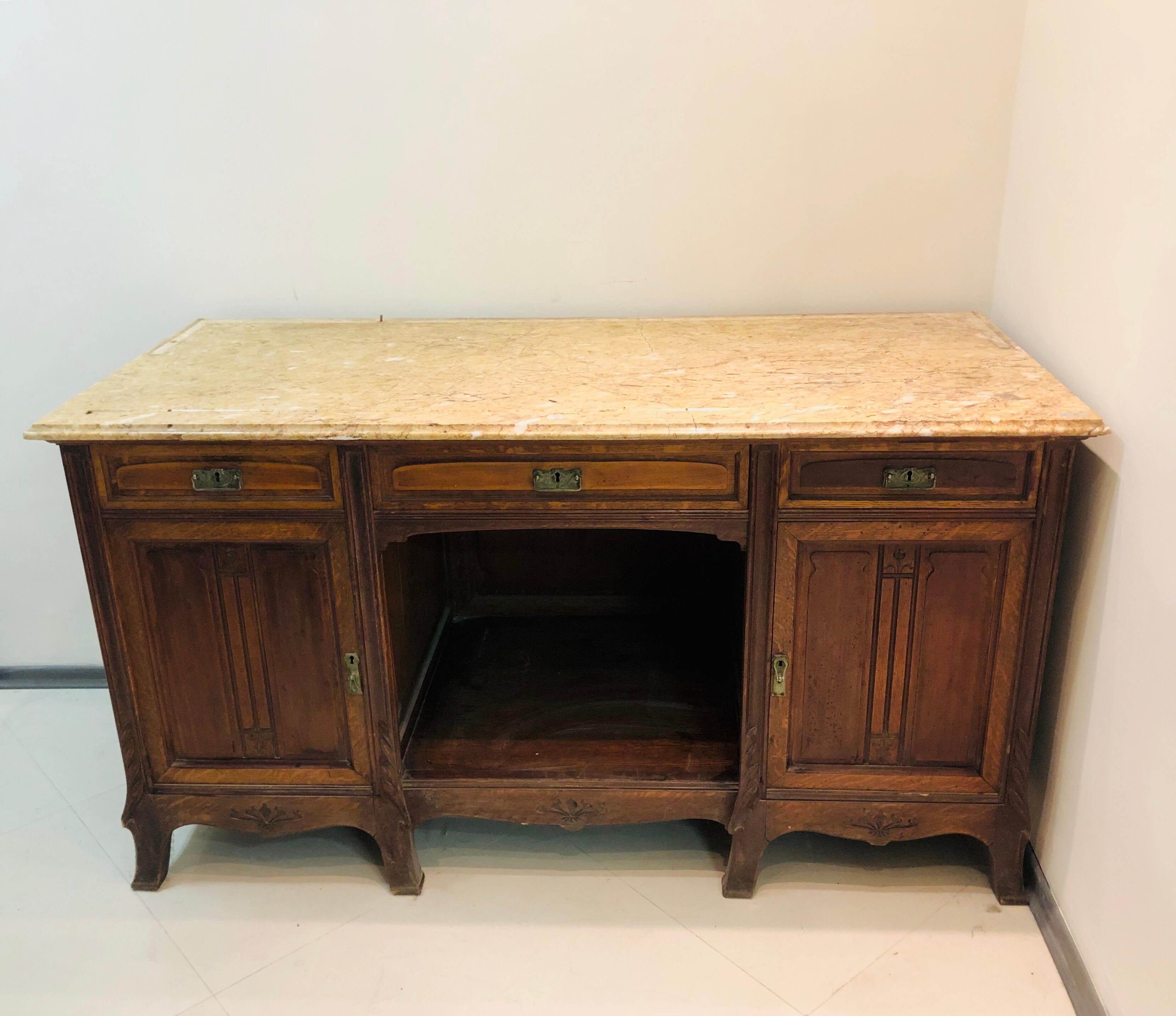 Large mahogany buffet Maison Koenig Liège made in 1895. There is light beige marble top, three drawers and two front doors with original key.
Could be used as a writing desk or as a center interior piece in a large bathroom with a sink on top of