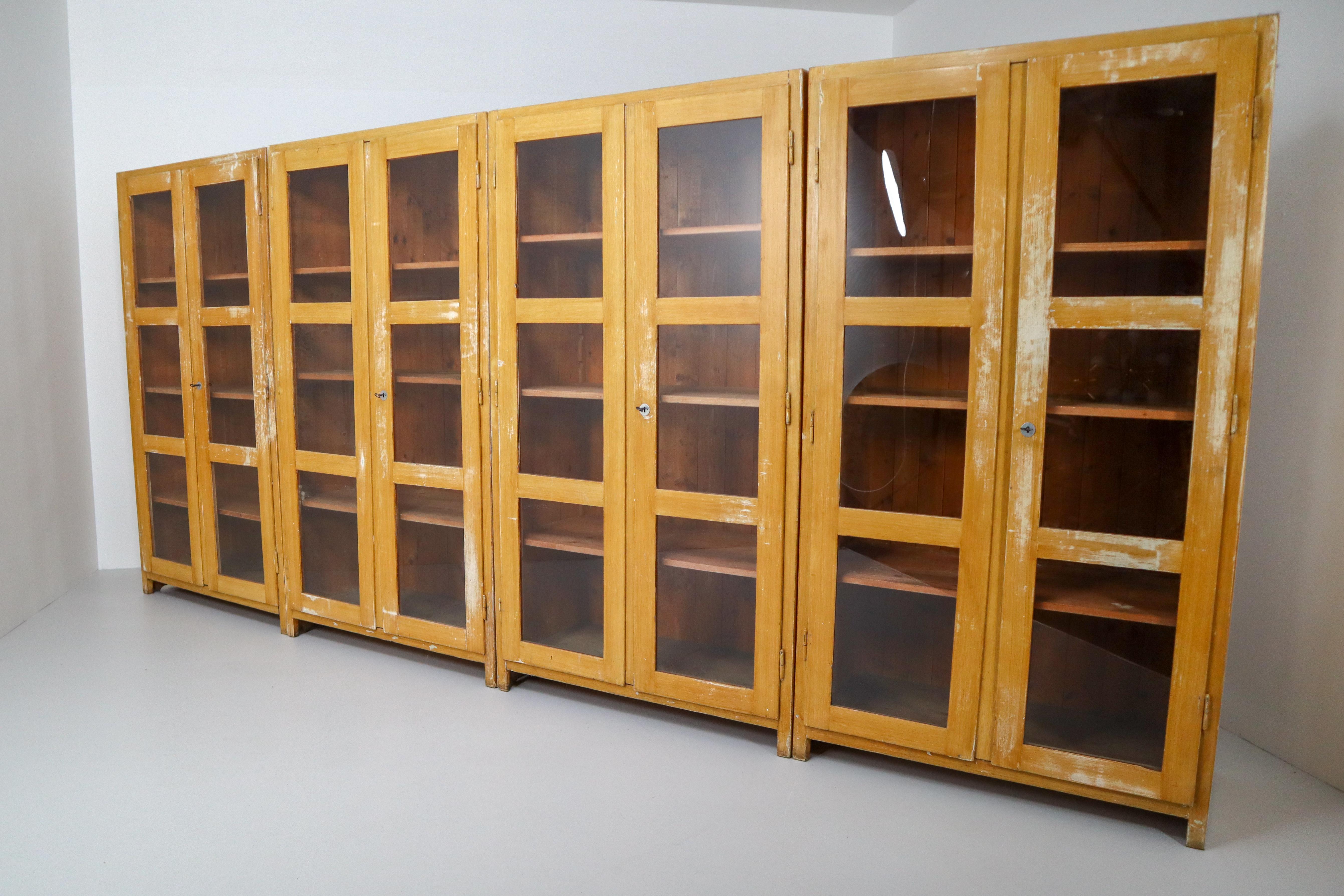 A large Primitive - vintage eight glazed doors storage /display cabinet with perfectly patinated paint made in France 1950s from solid French Pine .The wooden shelves can be height adjusted. Pieces like this with original paint are hard to find and