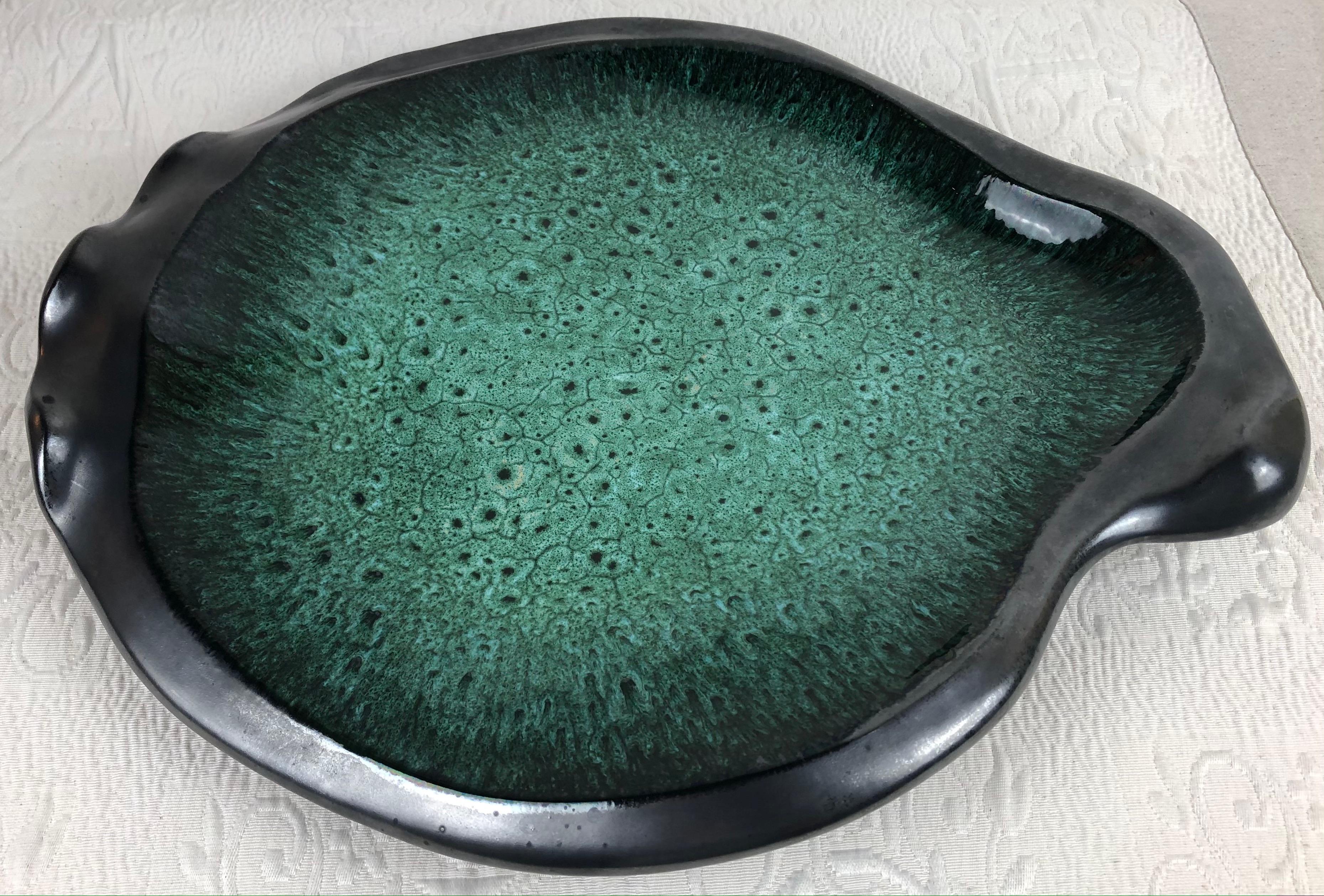 Stunning very large French ceramic bowl or platter, signed.
This mid-century piece features magnificent colors of various shades of glazed green and a black matte finish on the base.

Measures: 19 3/4