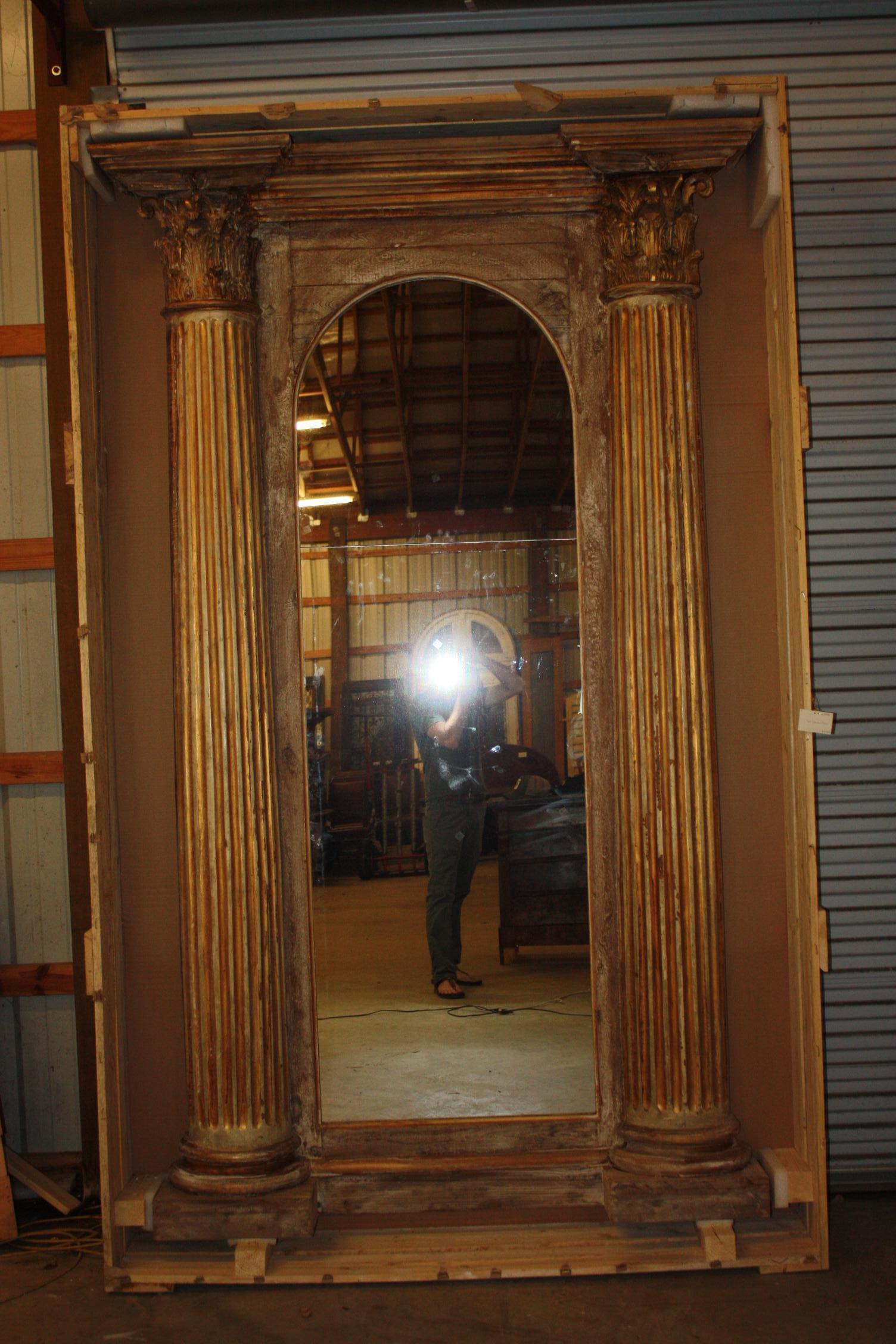 This is a very nice very large French mirror flanked by fully fluted Corinthian columns. This mirror appears to be of a more recent age made of older pieces. The glass of the mirror is in two panels. This would make a great full mirror.