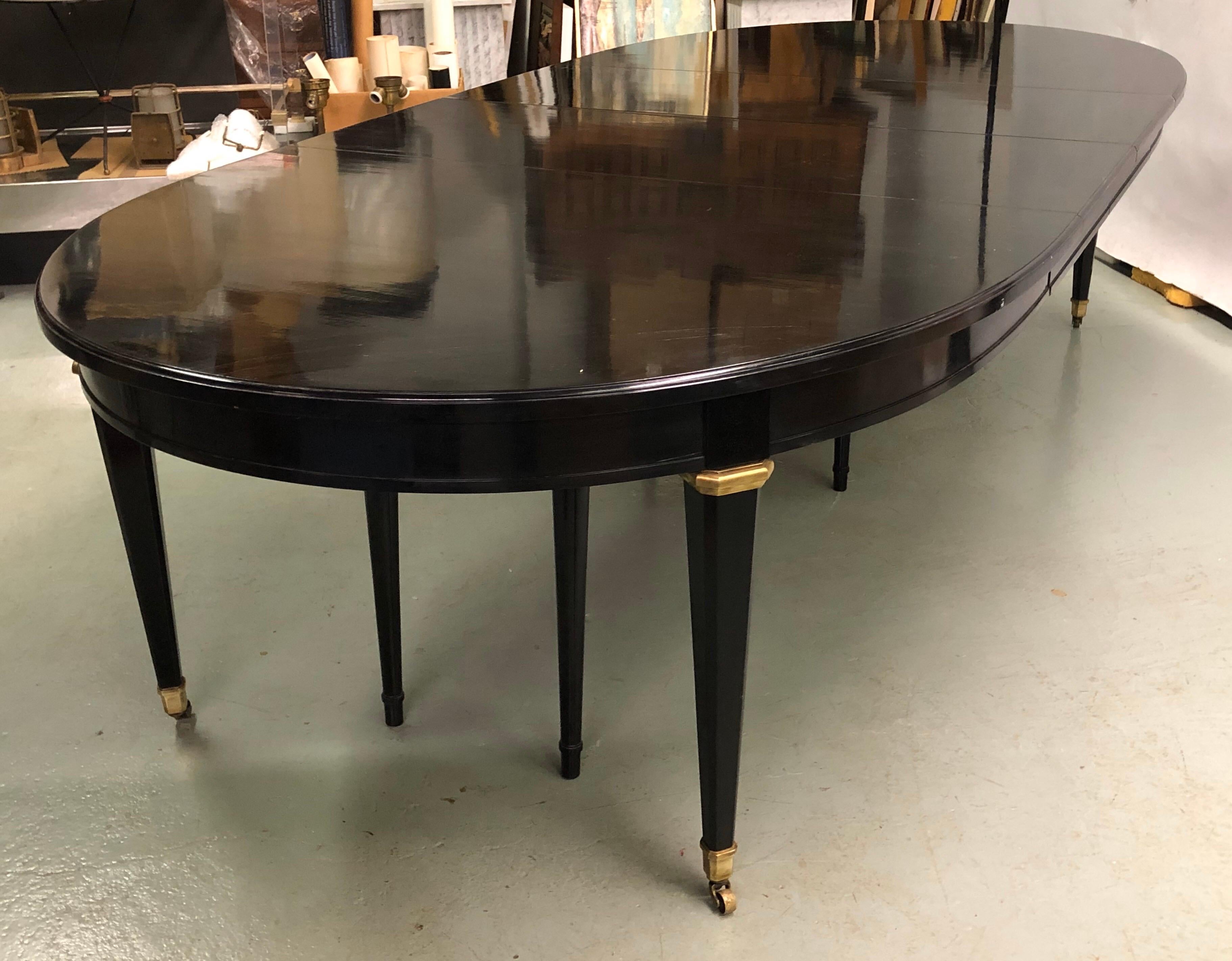 An exceptional and luxurious French ebonized mahogany dining room table in the modern neoclassical style of Louis XVI by Maison Jansen. 

The table is sober in it's design aesthetic with it's sleek, sensuous oval form. It features a 118