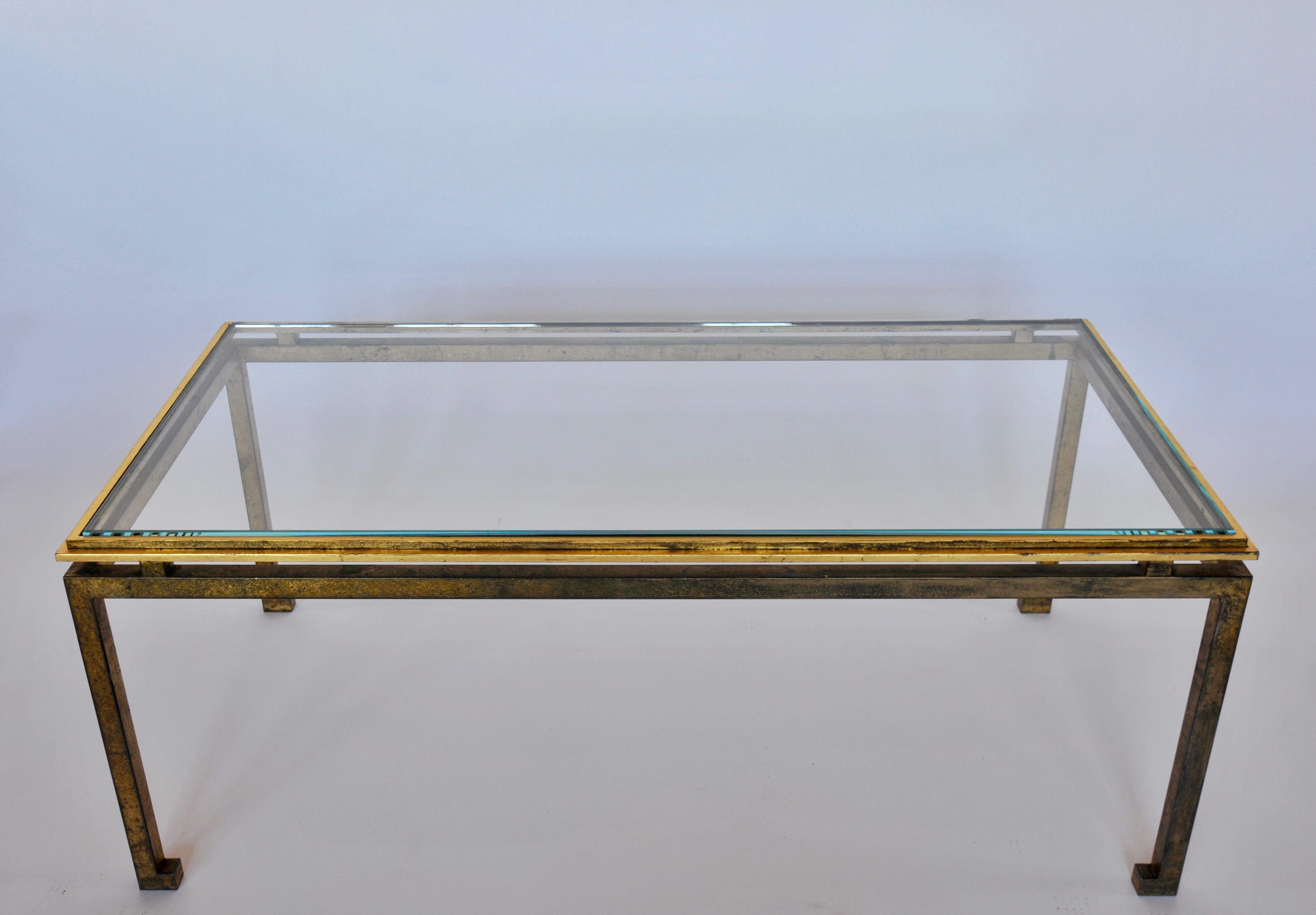 A large, elegant, timeless French midcentury style modern neoclassical, gilt iron coffee table in the style of Maison Ramsay. The table features Classic Ramsay details such as turned in feet and a cantilevered top suspended over the frame and legs