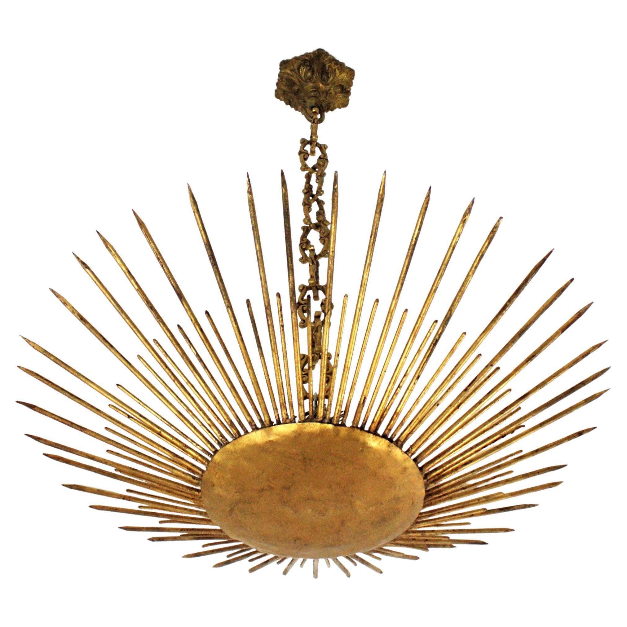 Gilt Iron Modern Neoclassical Sunburst Chandelier / Light Fixture, France, 1940s
This stunning hand-hammered gilt iron sunburst ceiling pendant was manufactured at the Art Deco Period. It has accents in transition to Brutalist style. 
A sunburst