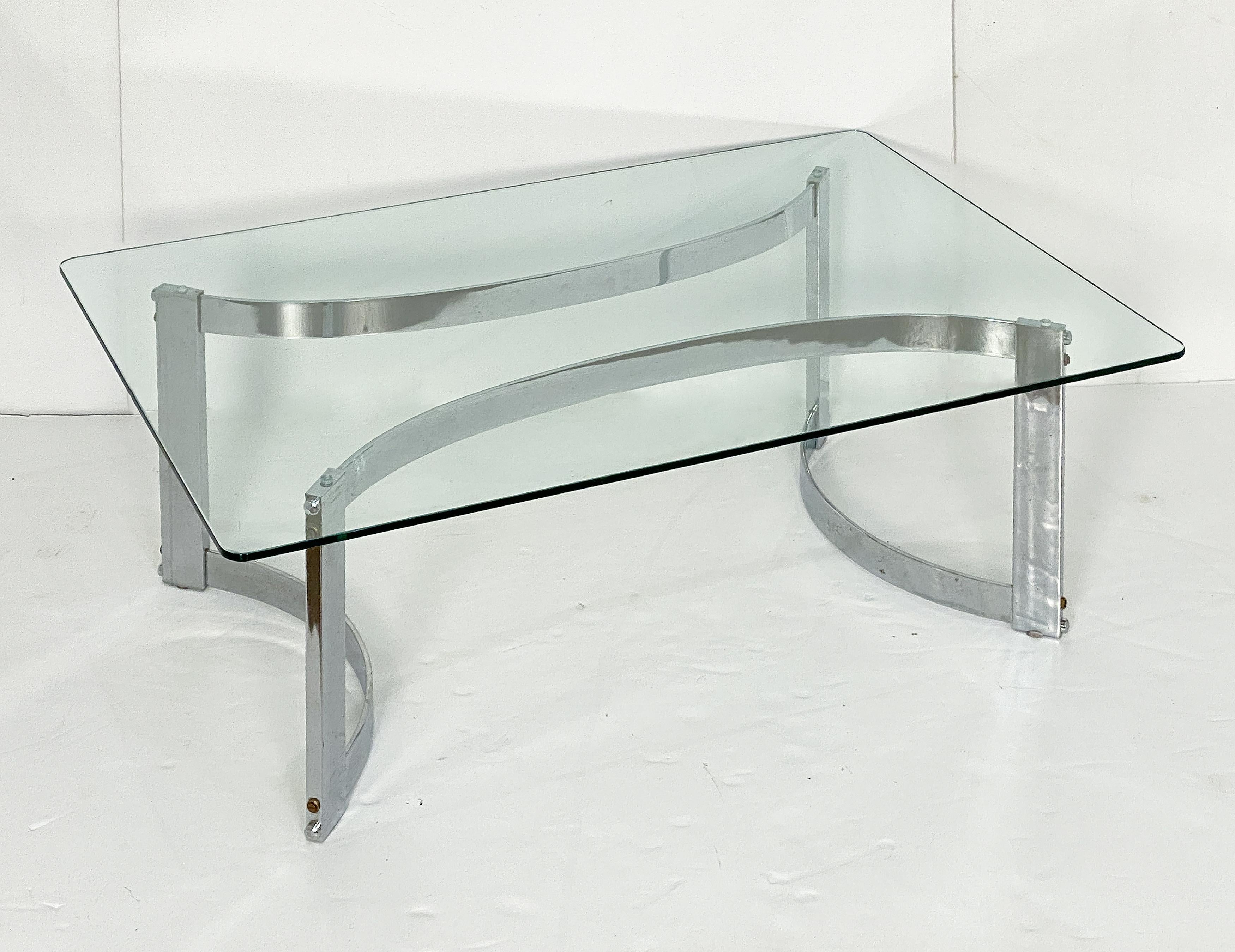 Belle table basse rectangulaire (ou table basse ou table de cocktail) en chrome et verre, dans le style de Paul Legeard, avec un plateau rectangulaire en verre reposant sur une base chromée en forme d'arcs opposés.