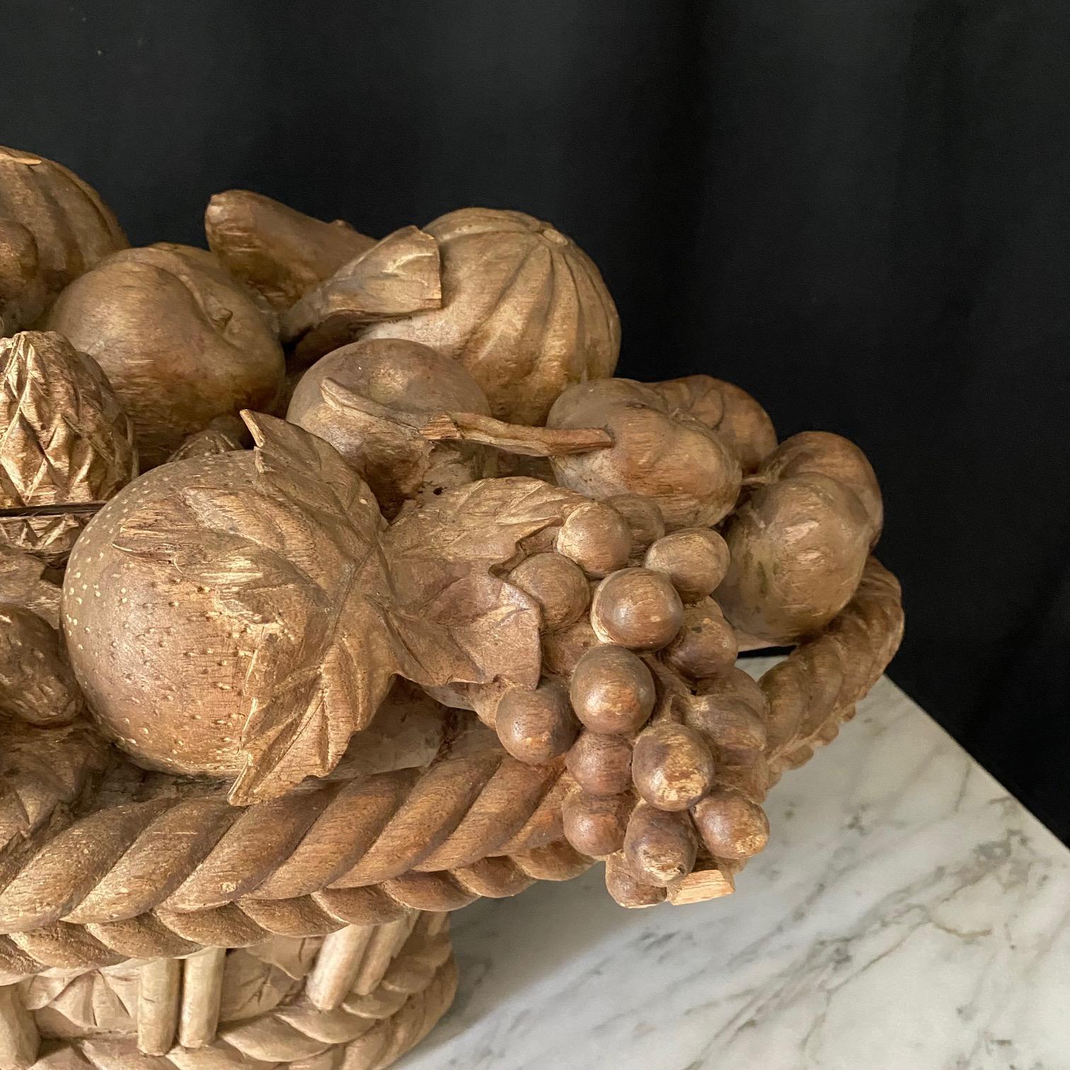 Stunningly large and detailed French carved woven basket filled with fruit. A cornucopia, this beautiful artwork depicts stunningly carved grapes, apples, and all kinds of fruit, wonderfully arranged in a braided woven basket base, all one solid