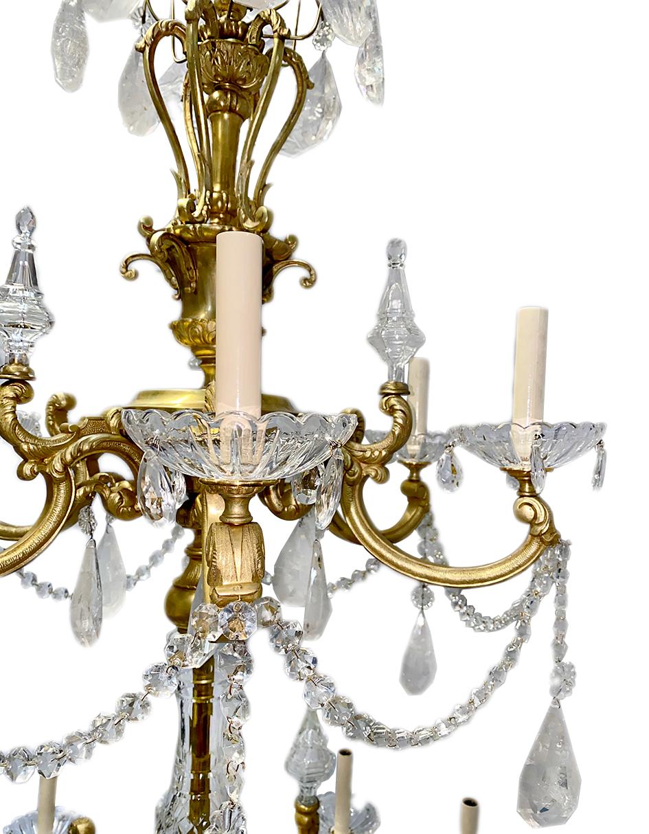 A circa 1900's gilt bronze double-tiered chandelier with rock crystal and crystal pendants.

Measurements:
Diameter: 40