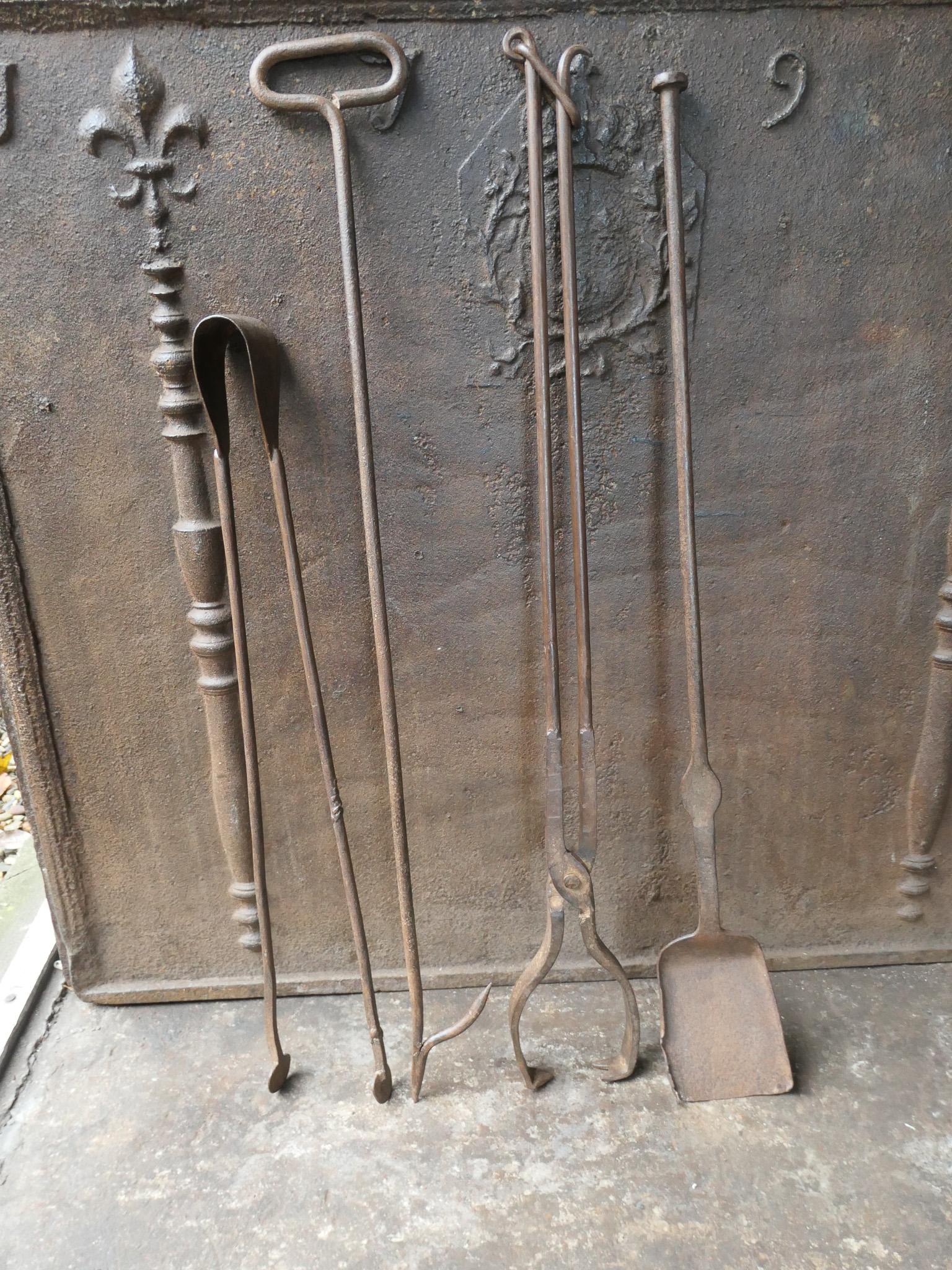 Large 18th-19th century French fireplace tool set. The tool set consists of tongs, shovel, poker and log tongs. The tools are made of wrought iron. The set is in a good condition and fit for use in the fireplace.