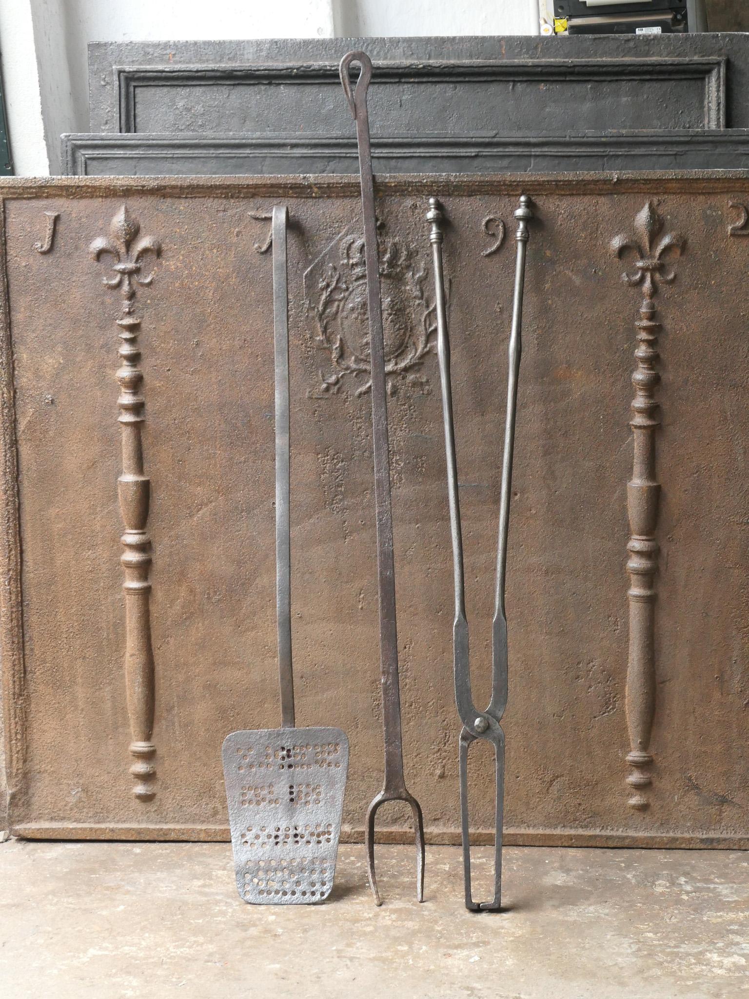Large 18th-19th century French fireplace tool set. The tool set consists of fireplace tongs, shovel and a fire fork. The tools are made of wrought iron. The set is in a good condition and fit for use in the fireplace.