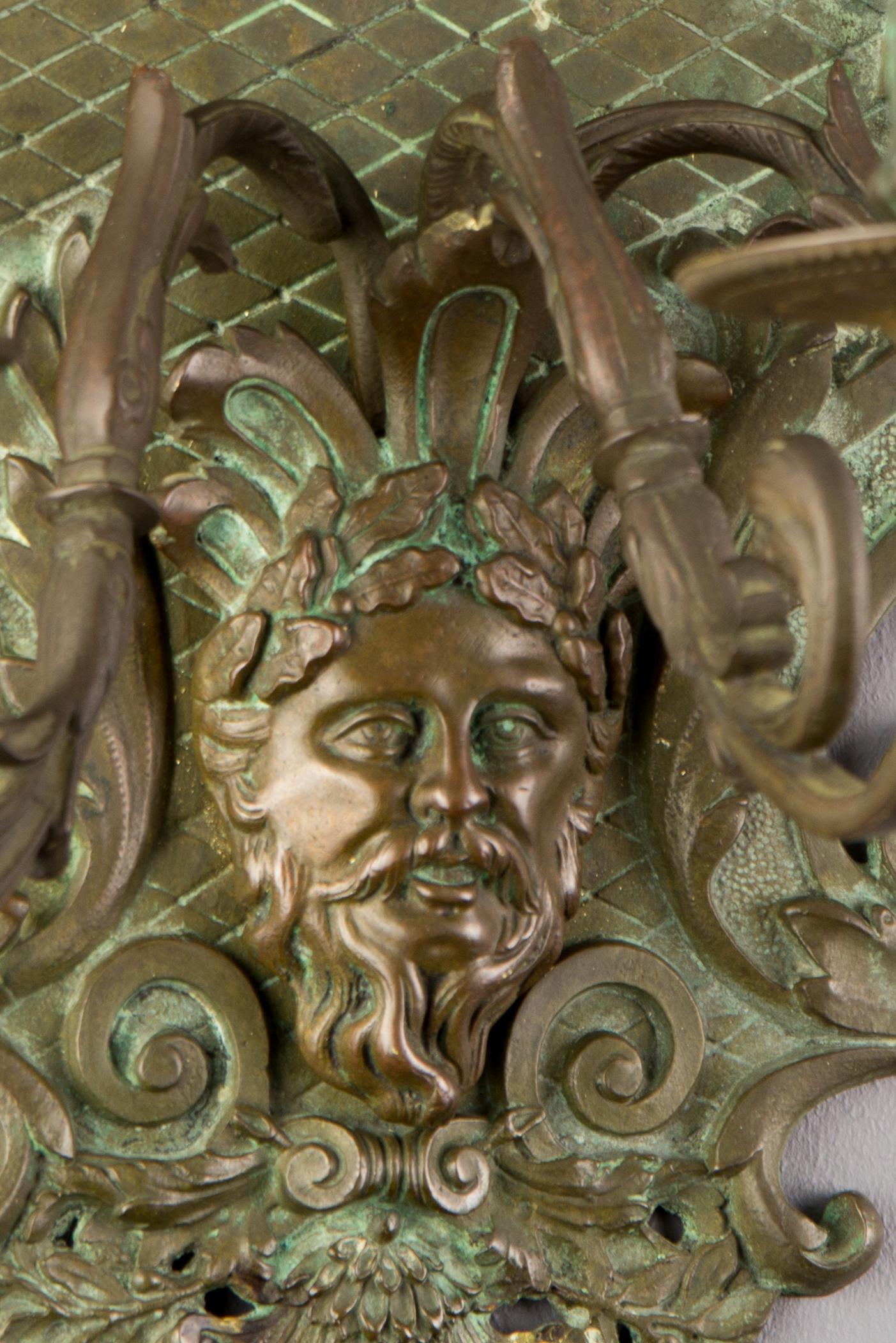 Impressive neoclassical or Louis XVI style wall light, decorated with ornamental motifs based on Greek and Roman sculpture: acanthus leaves, laurel wreaths, helmet, sheaves of the arrow, faces and in the center embellished with a fine figural mask.