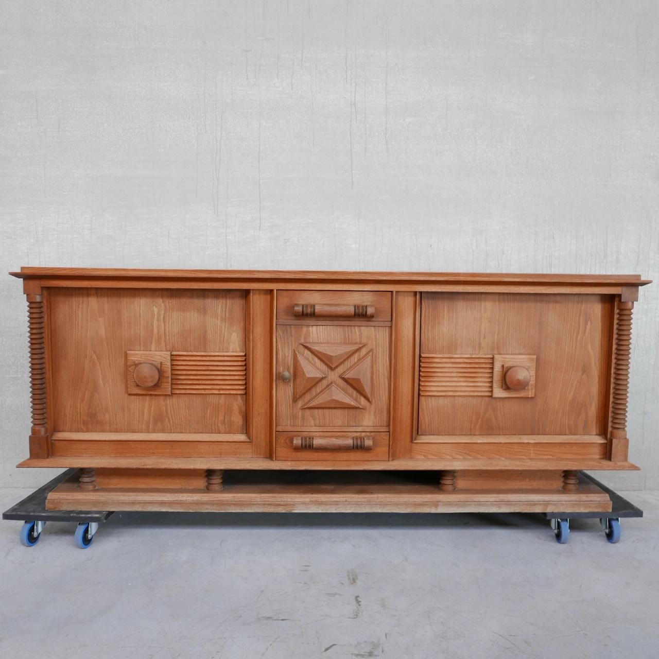 A large sideboard/credenza attributed to Charles Dudouyt. 

France, c1940s. 

Two doors with internal shelves to each side, a central door inbetween a drawer above and below. 

In near immaculate condition.

Location: Belgium Gallery.