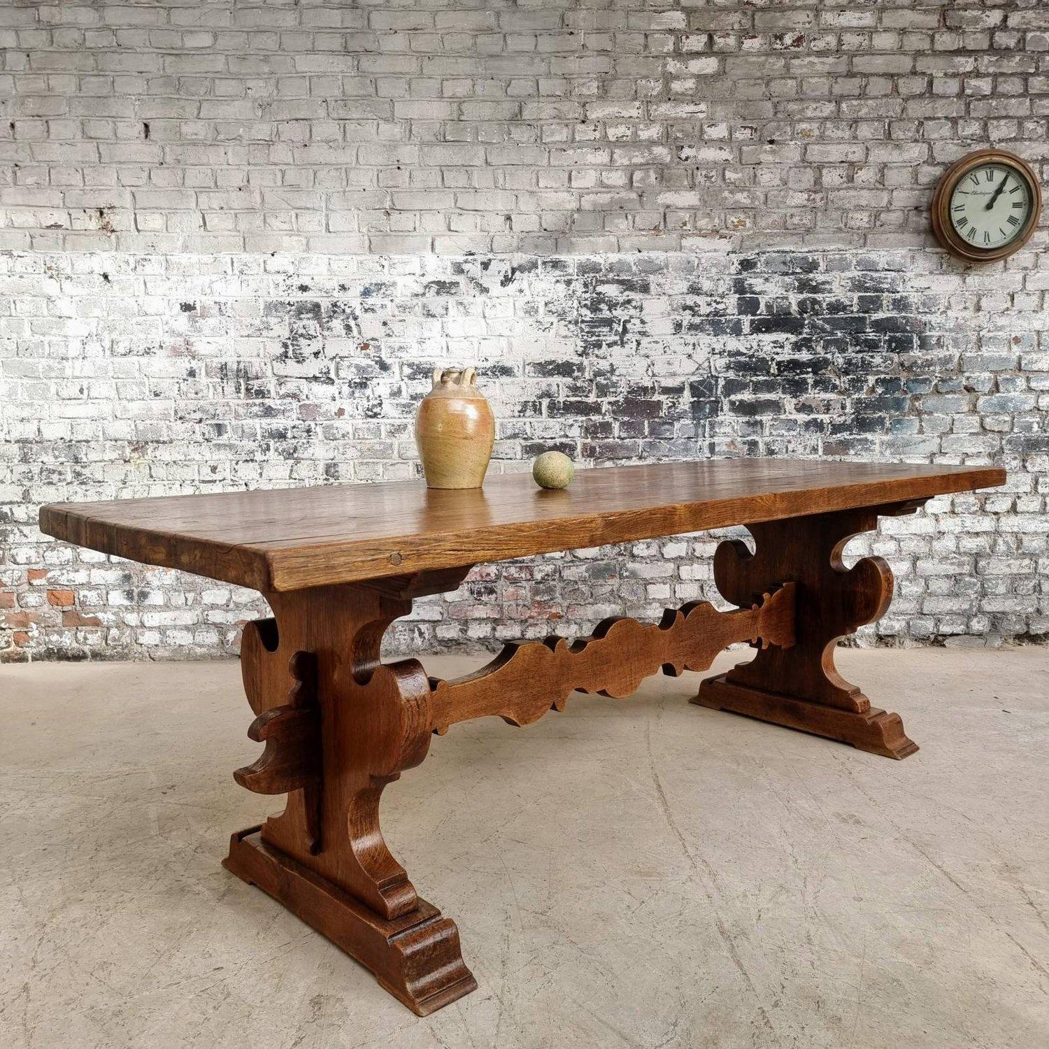 This stunning French late 19th century oak table features an eye-catching decorative stretcher, and it is a vintage treasure that exudes elegance and character. Likely sourced from a ski resort, it is made of solid oak and features a rich,