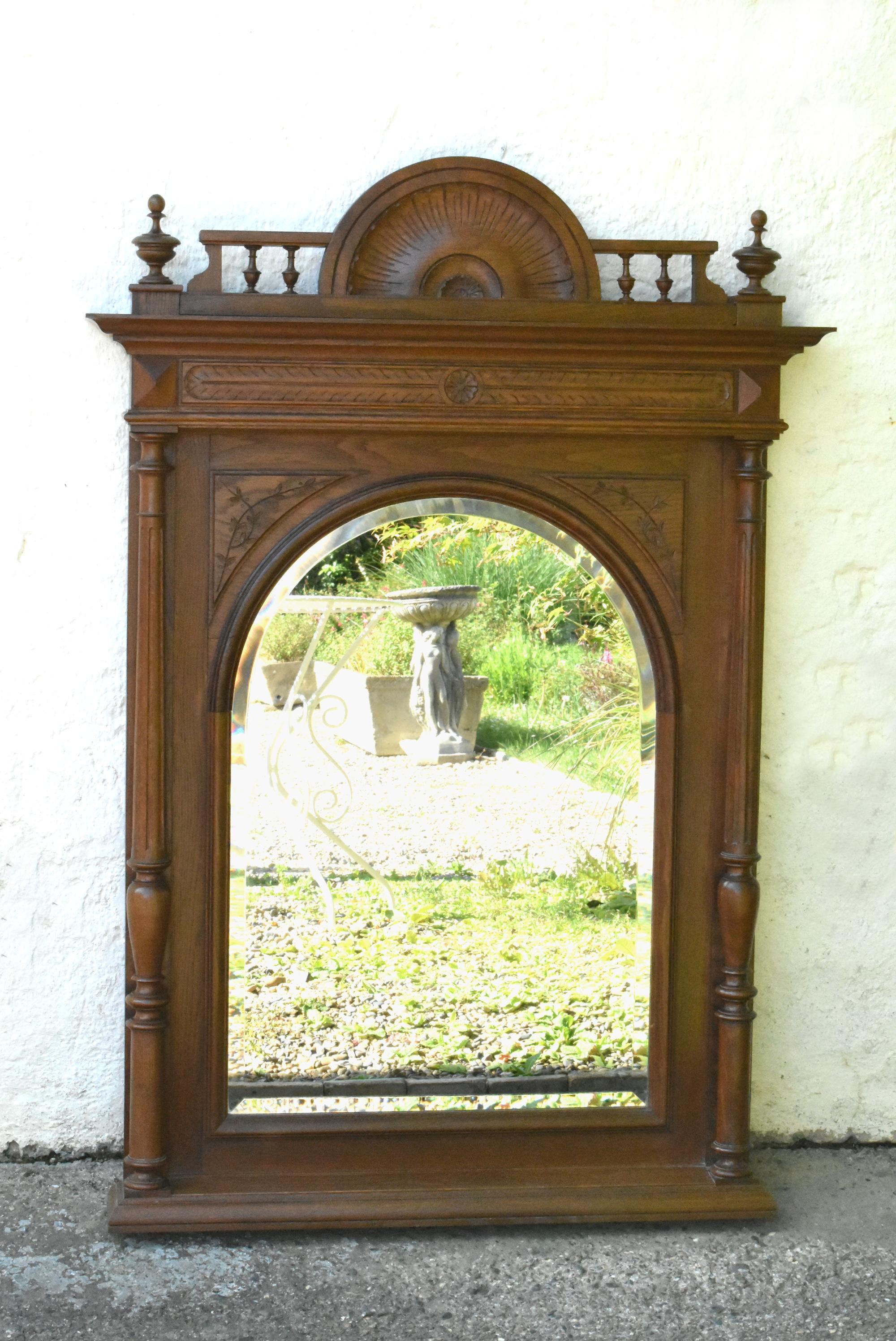 Large Oak Overmantel Mirror Henri II

This impressive overmantel mirror features an arched bevelled mirror plate set into a solid oak frame.

The original mirror is flanked on both side by turned tapered columns.

To the top is a demilune crest set