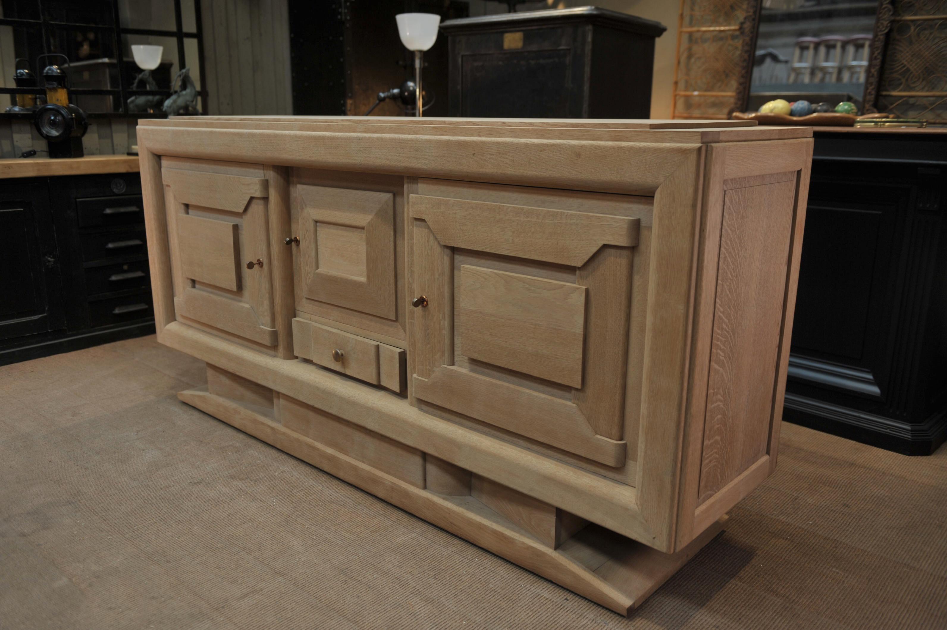 Three doors and one drawer large sideboard by French Designer: Charles Dudouyt with several inside adjustable shelves. The top part of this credenza comes out of the typical Charles Dudouyt base. Original working keys. All in Natural oak, send