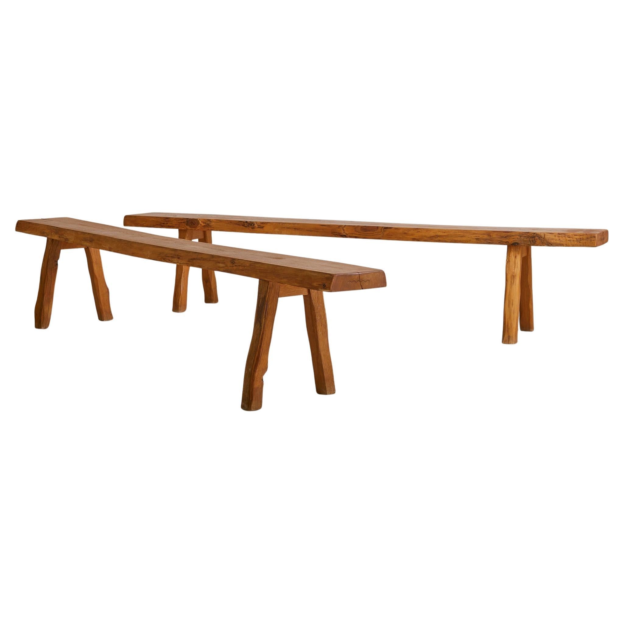 Sold and priced individually.

This large French bench from the 1960s is hewn entirely from solid wood, its form carved by hand and intuition. Featuring an irregular silhouette and subtly tapered legs, it showcases a raw finish that retains the