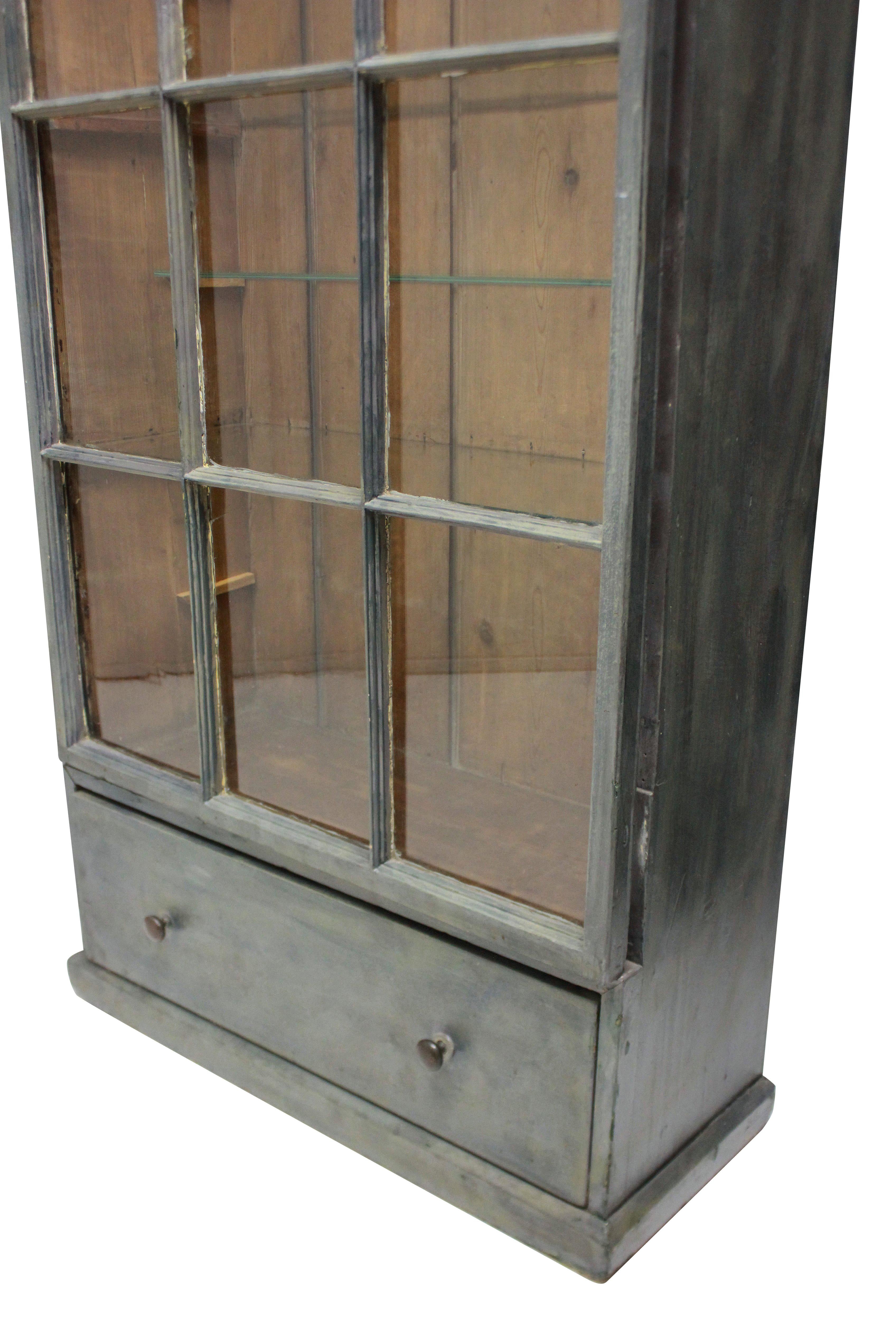 A large French painted display cabinet, with the original 19th century glazed door panels and glass shelves within.


