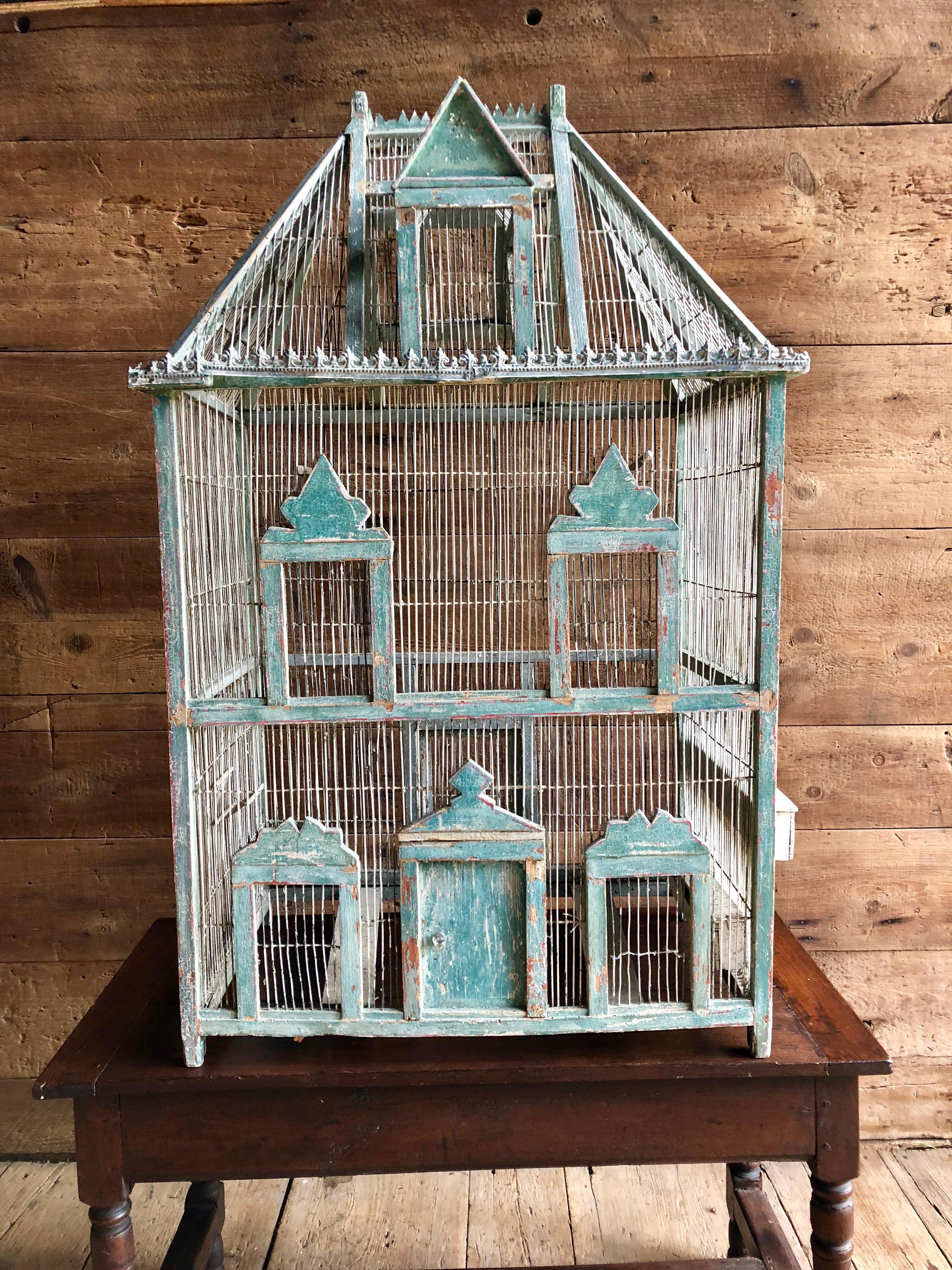 A large French painted birdcage in wire and wood in the form of a chateau, with original blue or green painted finish and embossed tin trim, 19th century.