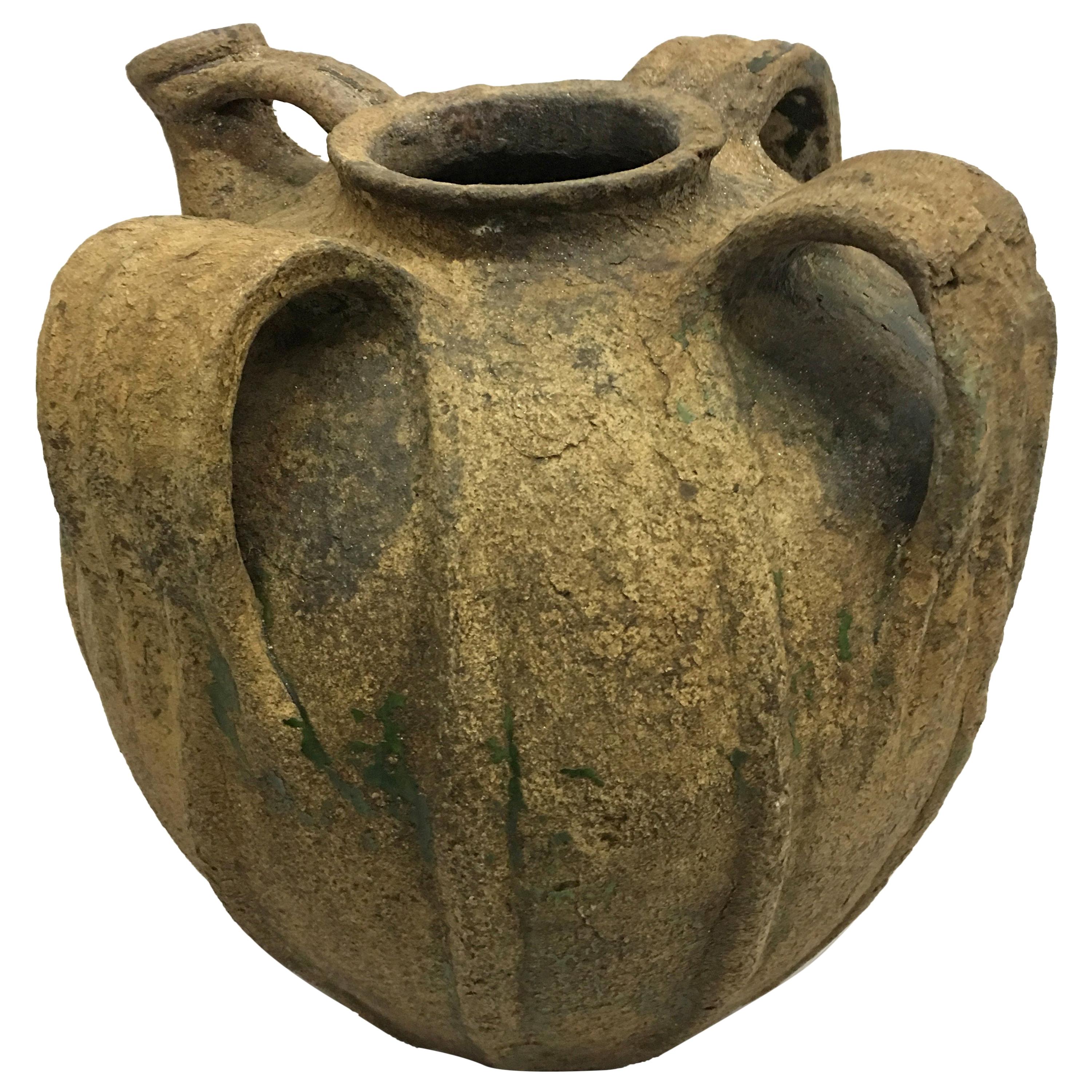 A timeless, Classic French 18th century provincial pottery / ceramic urn or pitcher with beautiful, natural time worn patina and a stunning form featuring three dramatic handles and deep ridging along the base.