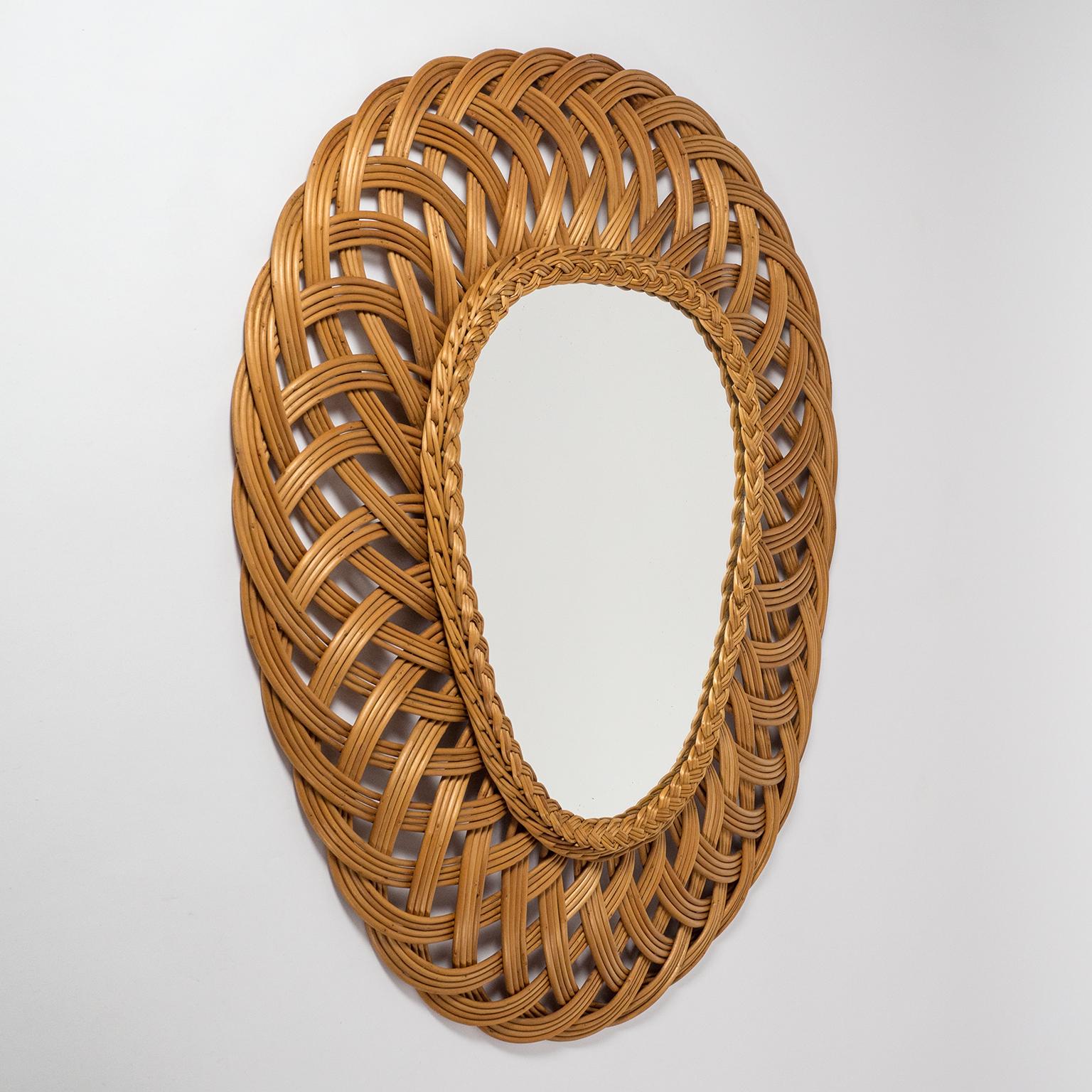 Very unique French artisanal rattan mirror from the late 1960s or early 1970s. Large oval frame made of 