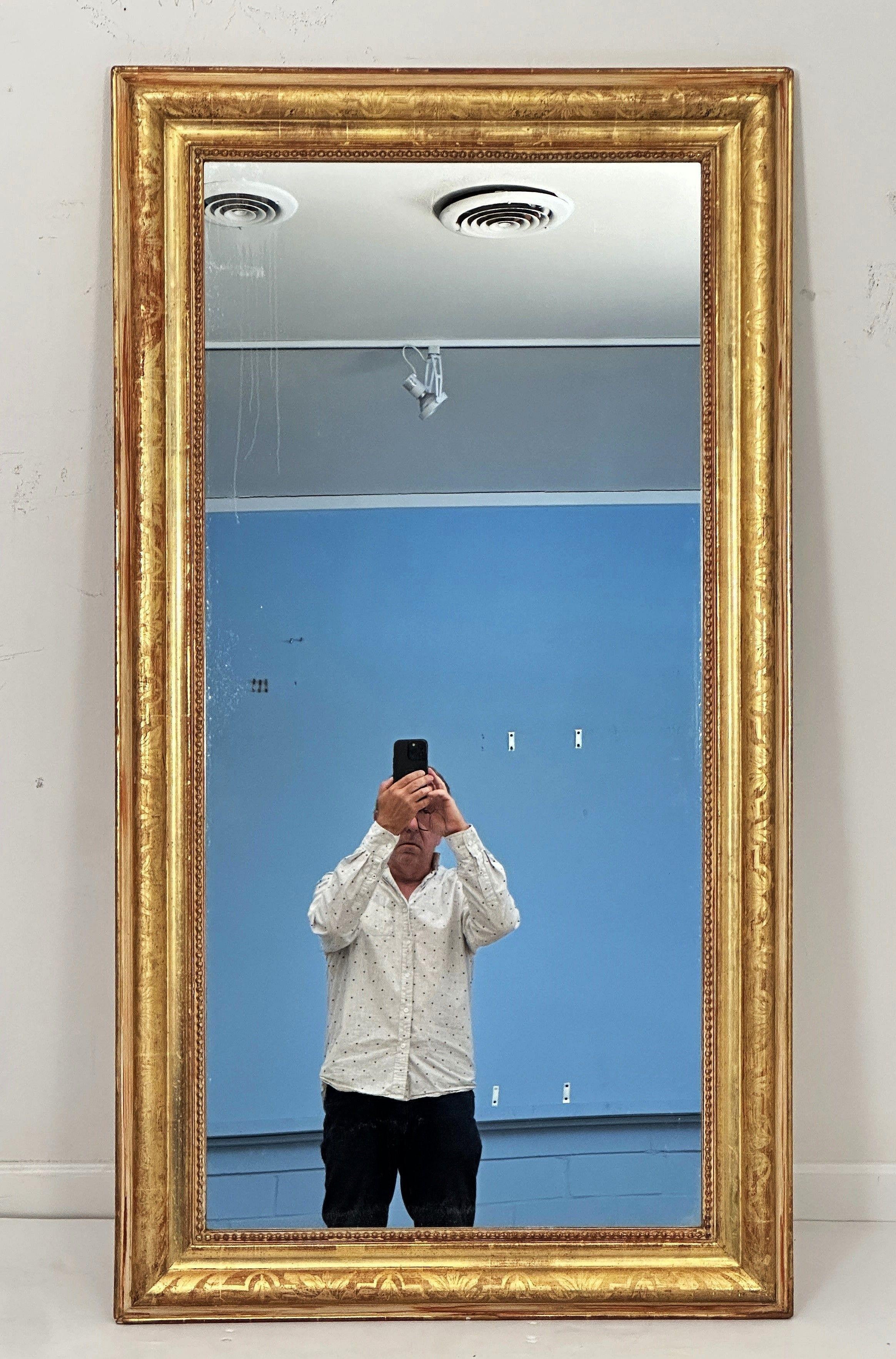 A fine large French rectangular hall or over-mantel mirror from the 19th century, featuring a moulded surround with a beautiful patinated gold-leaf - perfect for use as a free standing or dressing mirror or equally as a wall mirror which can be hung