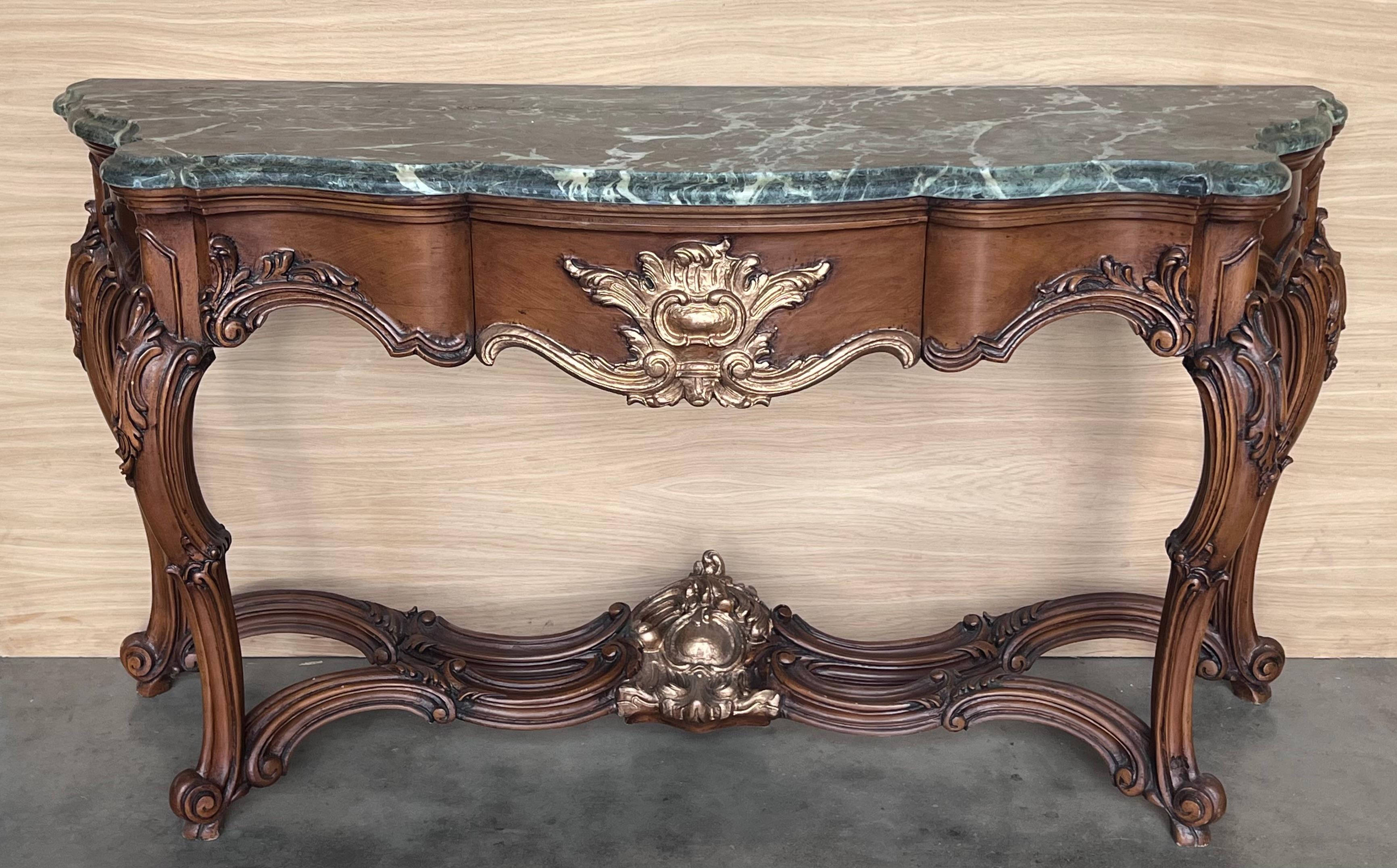 20th French Regency carved walnut console table with gilted edges 

20th century French Regence style beautifully carved with leaves walnut console. Green marble top with carved front, over hand-carved frieze supported by four cabriole legs. Very