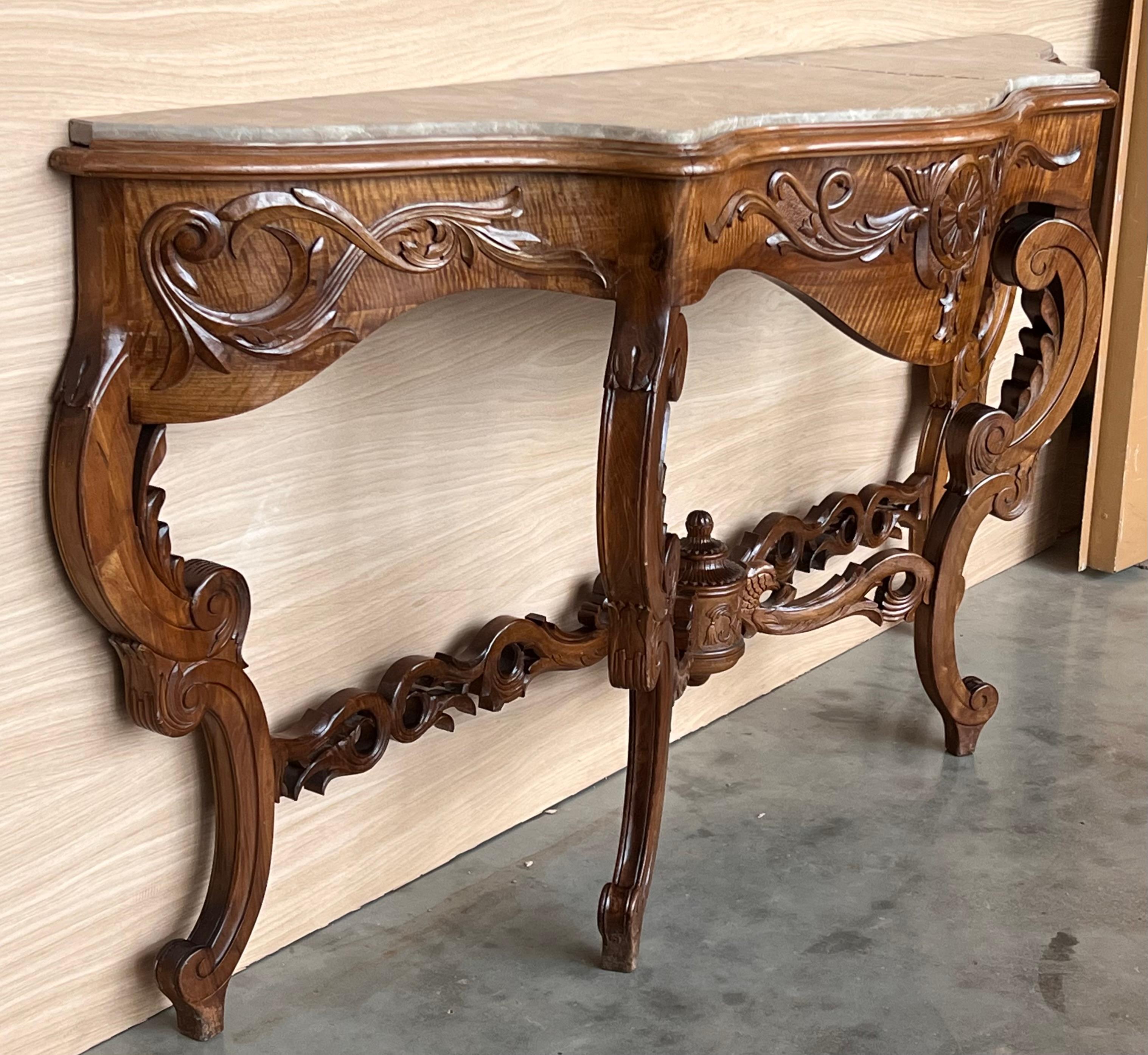 20th French Regency carved walnut console table with gilted edges 

20th century French Regence style beautifully carved with leaves walnut console. Wood top with carved front, over hand-carved frieze supported by four cabriole legs. Very massive