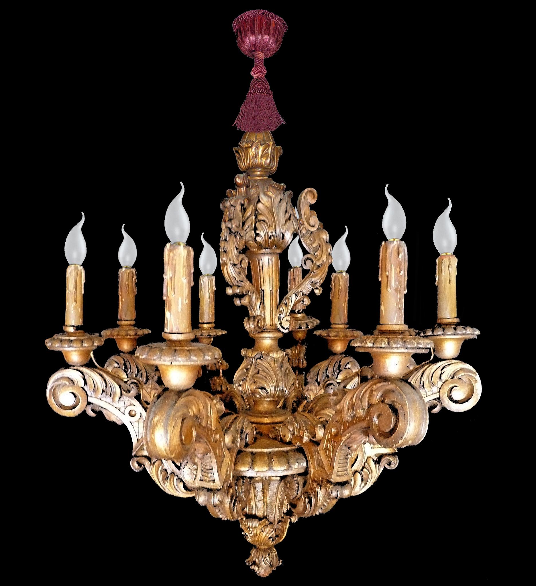 Grand lustre néoclassique en bois sculpté et doré, de style baroque, à cinq lumières. Les bras à volutes, ornés de feuillages, sont pincés jusqu'à un pommeau central à godrons, surmonté d'une tige balustre feuillagée et surmonté d'une fleur en forme