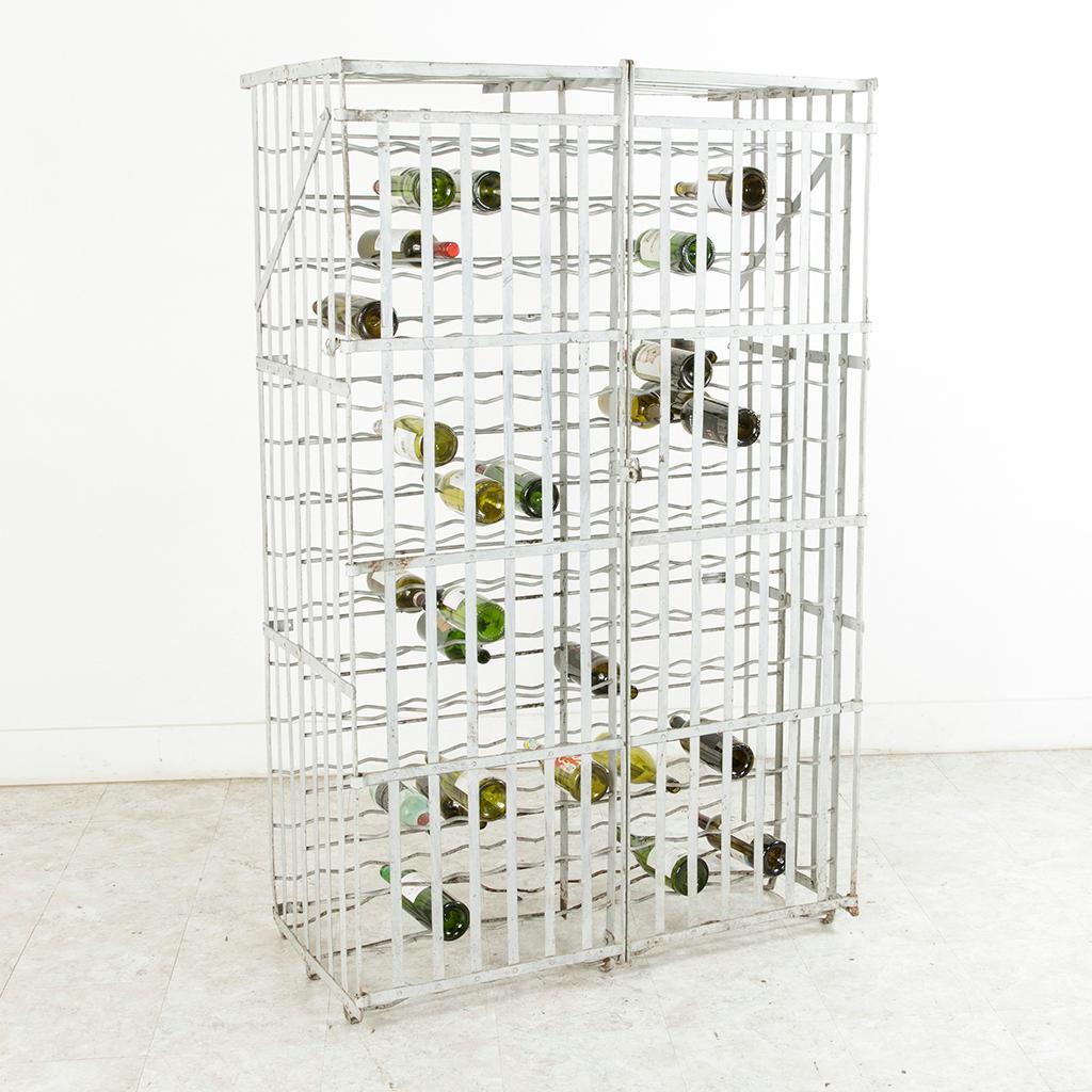 Manufactured circa 1900, this riveted iron wine cage or wine rack was originally attached to the wall in the wine cellar of a French restaurant though it may also remain freestanding. Painted in a Marie Antoinette grey, this piece has a capacity for