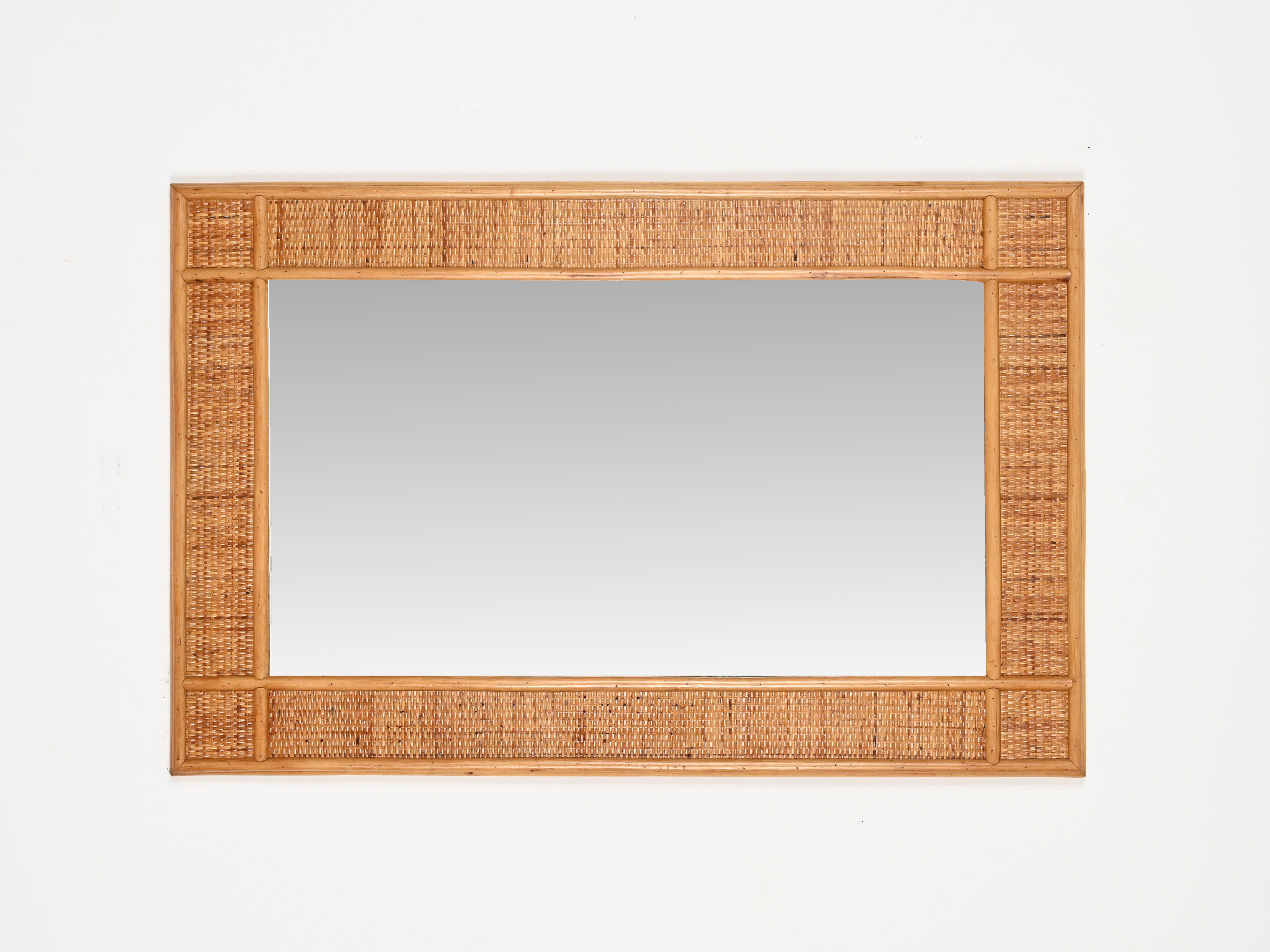 Maravilloso espejo rectangular de gran tamaño de mediados de siglo, totalmente realizado en bambú y mimbre de ratán tejido. Este singular espejo de estilo Riviera francesa se fabricó en Italia durante la década de 1970. 

En increíble estado y con