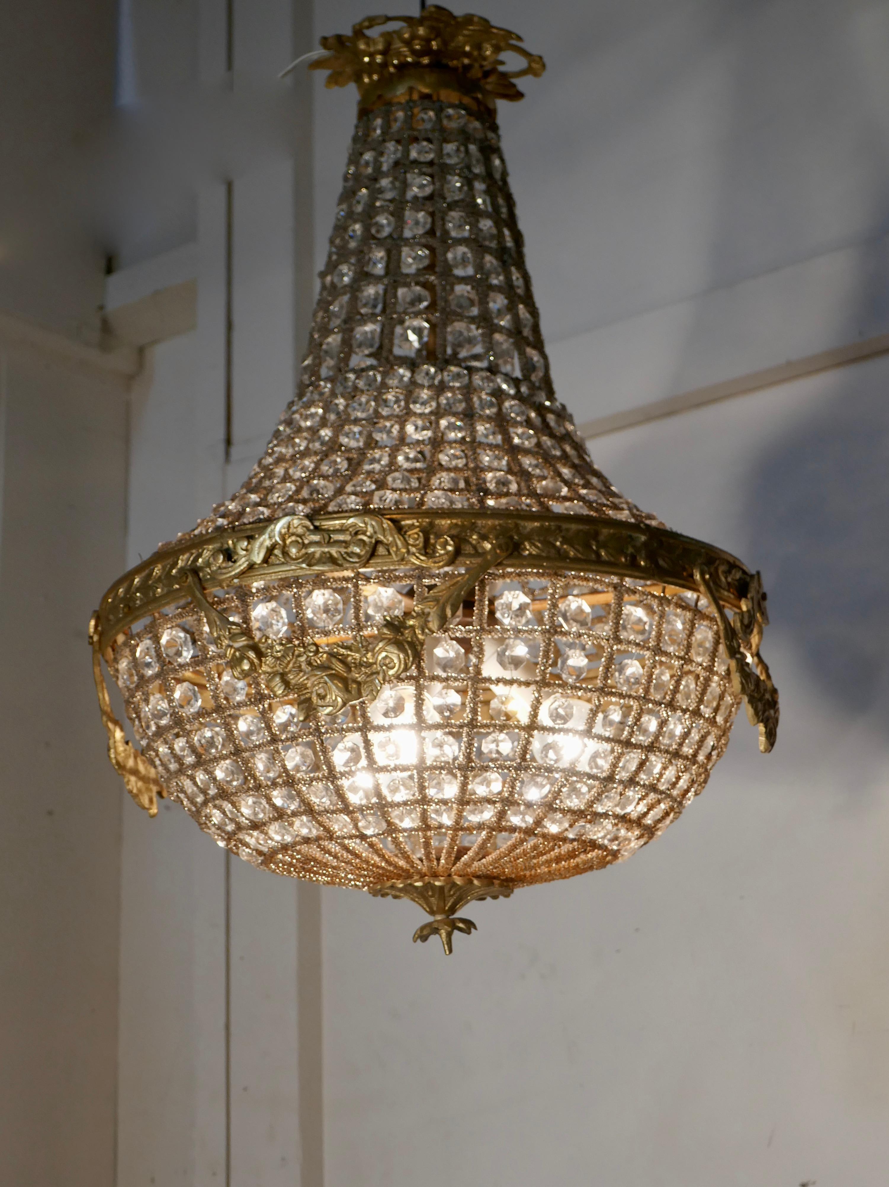 Large French Rocco style bag and tent chandelier

A fine piece, in age darkened brass and crystal, it has 3 bulbs giving a very attractive light

The brass frame is set with crystal stones, it is decorated with swags around the central rim