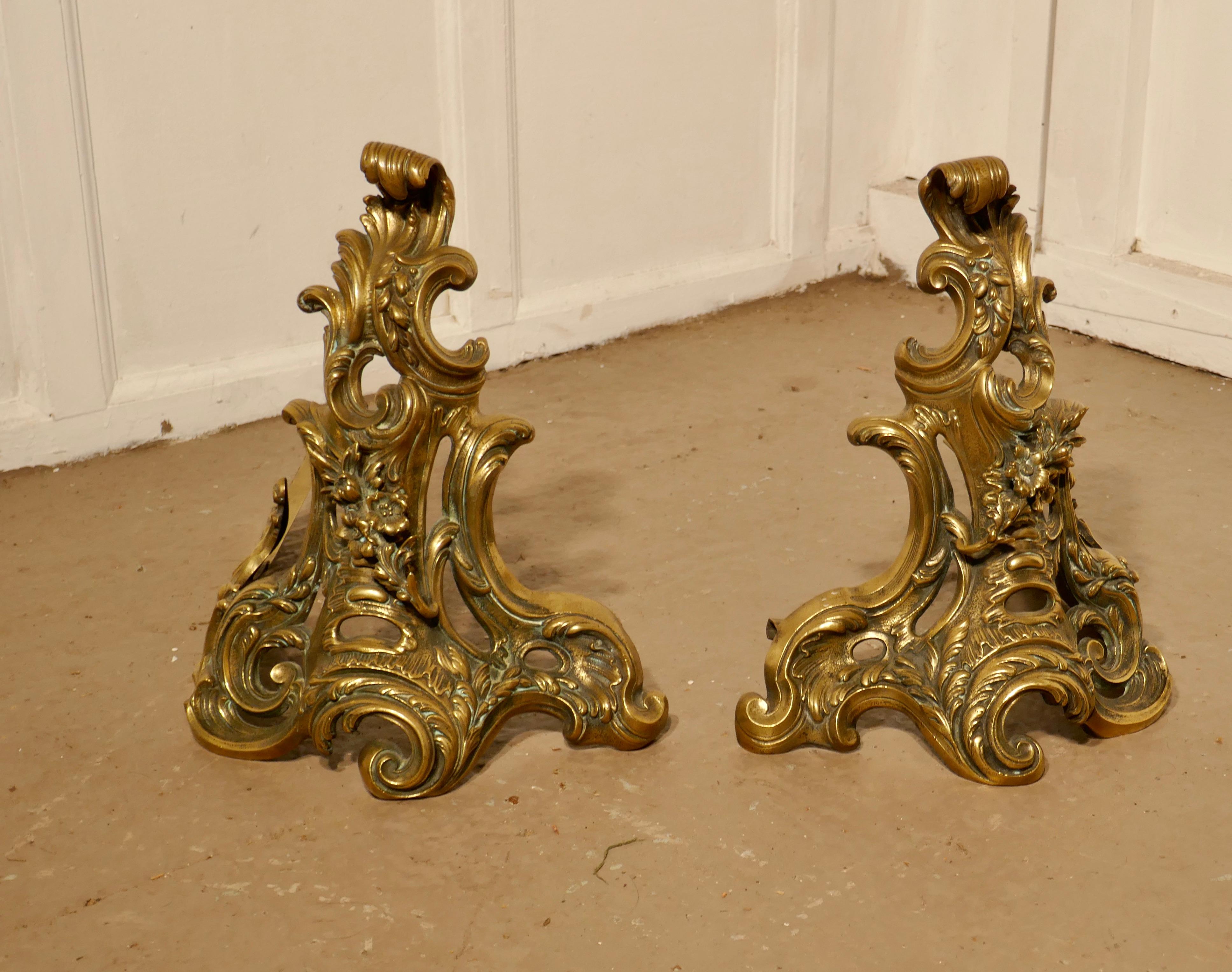 Large French Rococo brass extending fender with decorative chenets 
 
This is a superb piece, each end of the fender has an elaborate chenet decorated with flowers and leaves these can be used alone as andirons, however there is also the centre